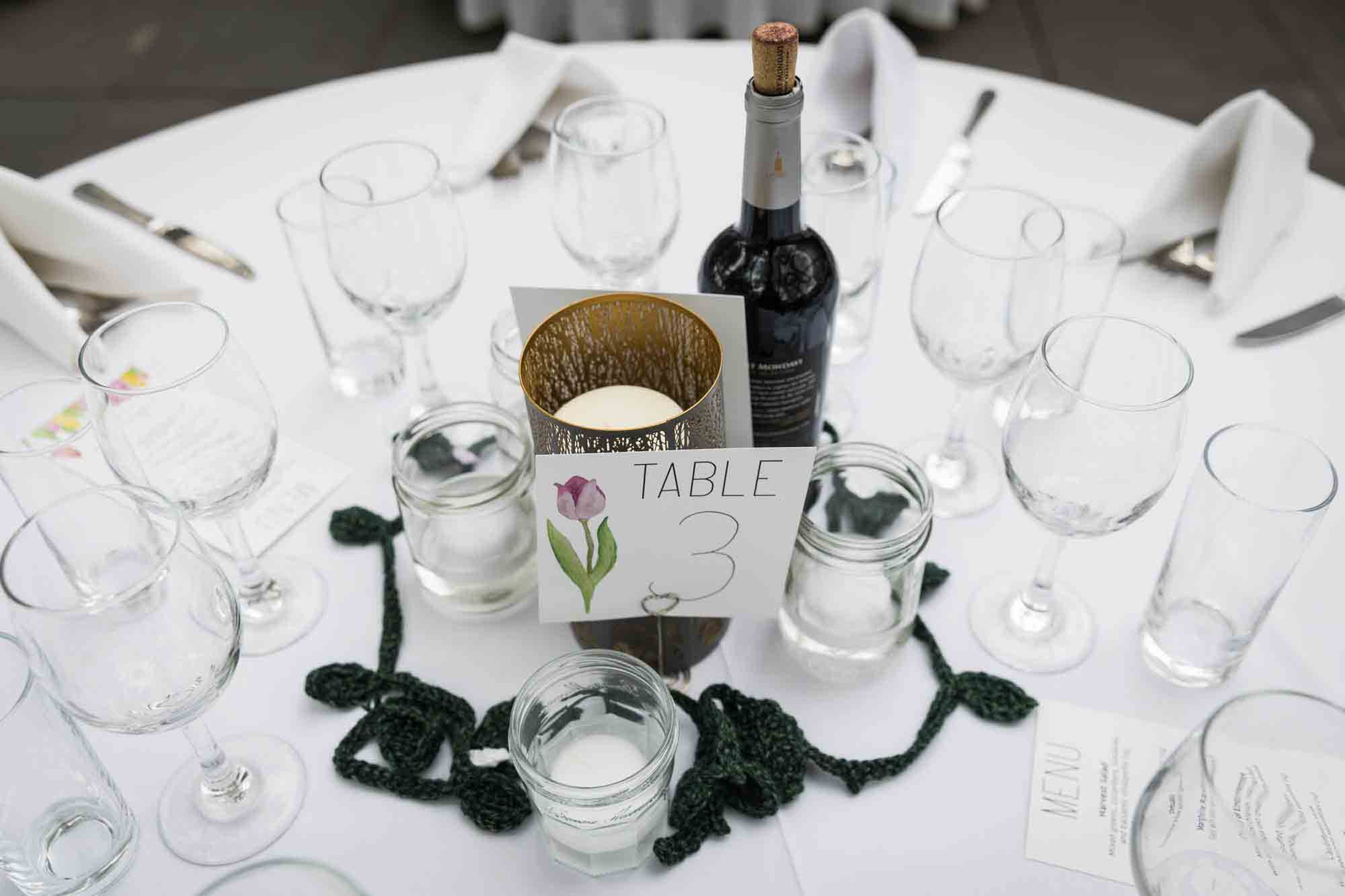 Table setting with glasses, candles and wine bottle at a Sanctuary Roosevelt Island wedding