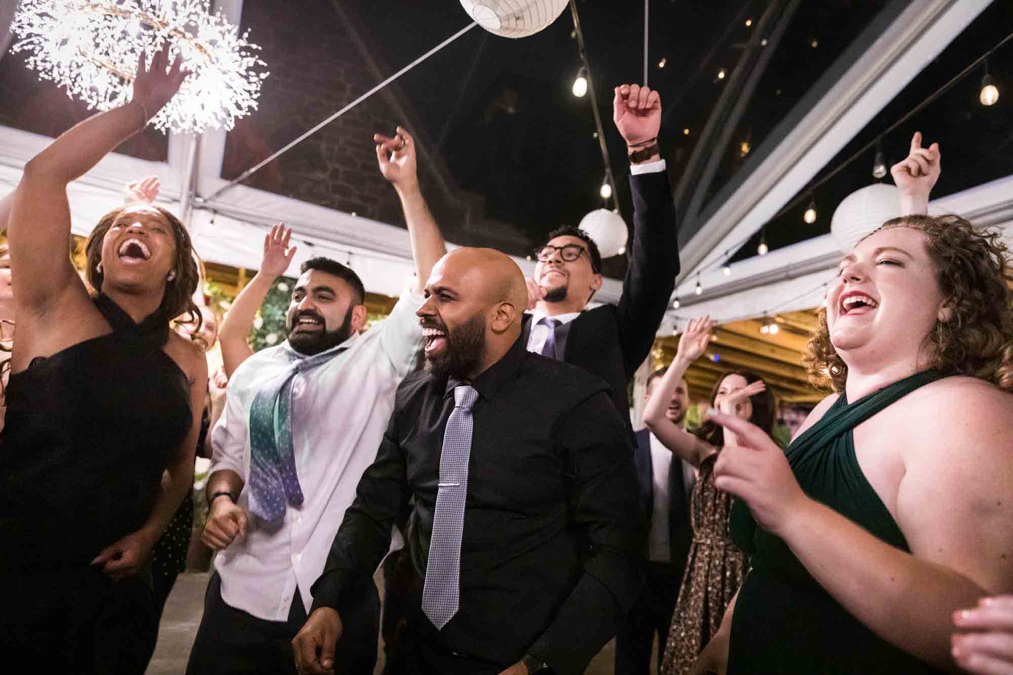 Guests dancing with hands in the air at a Sanctuary Roosevelt Island wedding