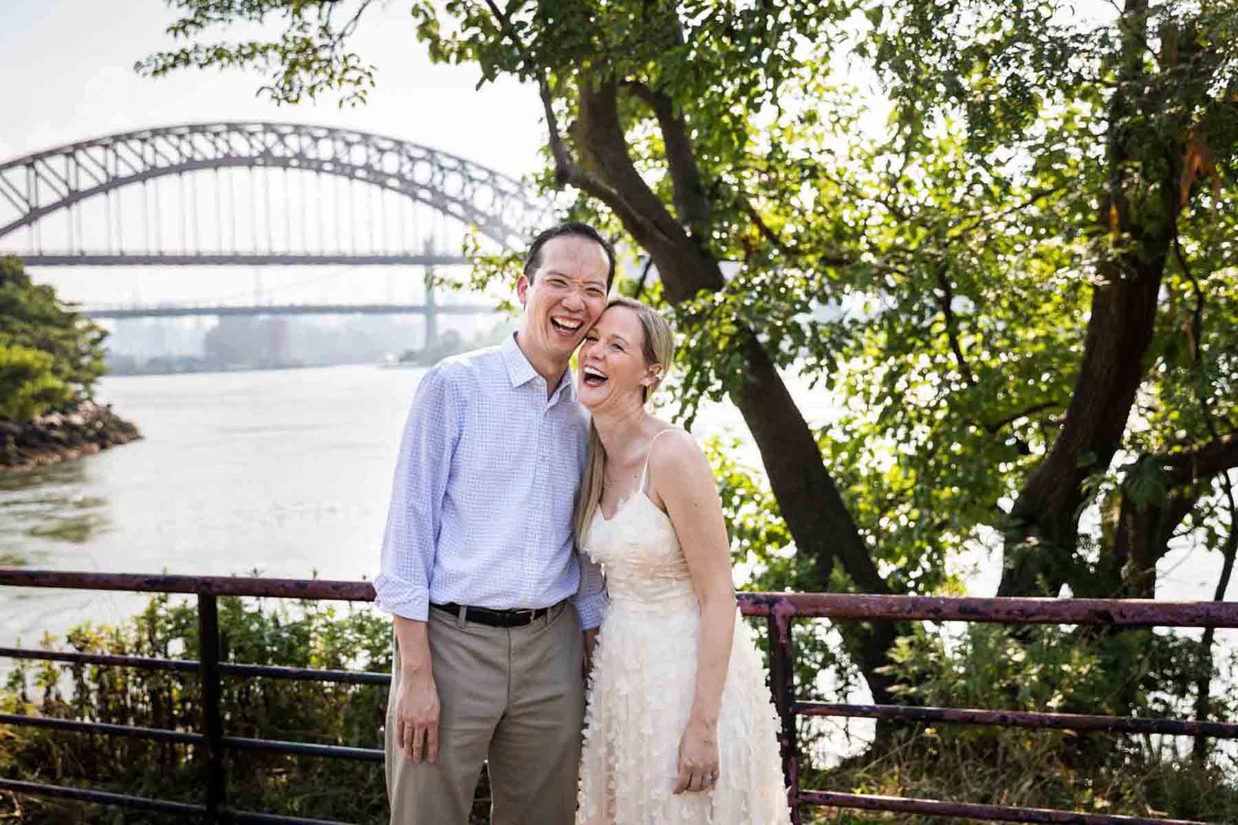 Astoria Park engagement photos of a couple hugging along waterfront