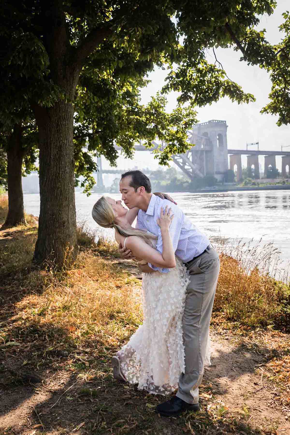 Astoria Park engagement photos of a couple kissing along waterfront