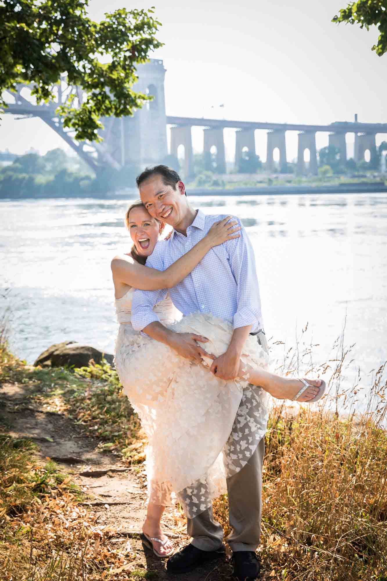 Astoria Park engagement photos of a couple hugging along waterfront