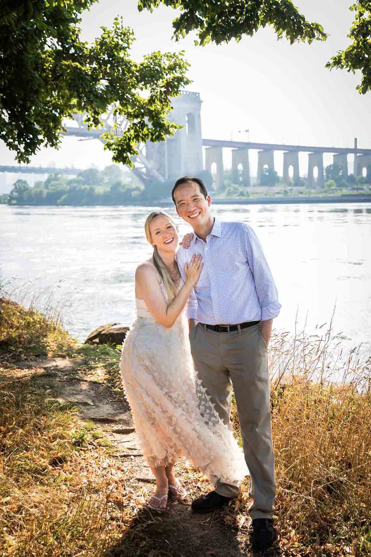 Astoria Park engagement photos of a couple hugging along waterfront