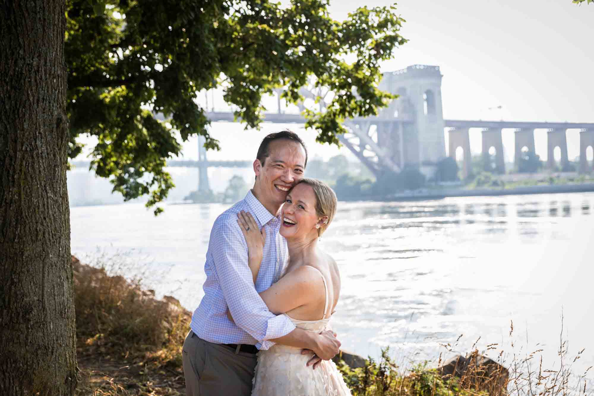 Astoria Park engagement photos of a couple hugging along waterfront