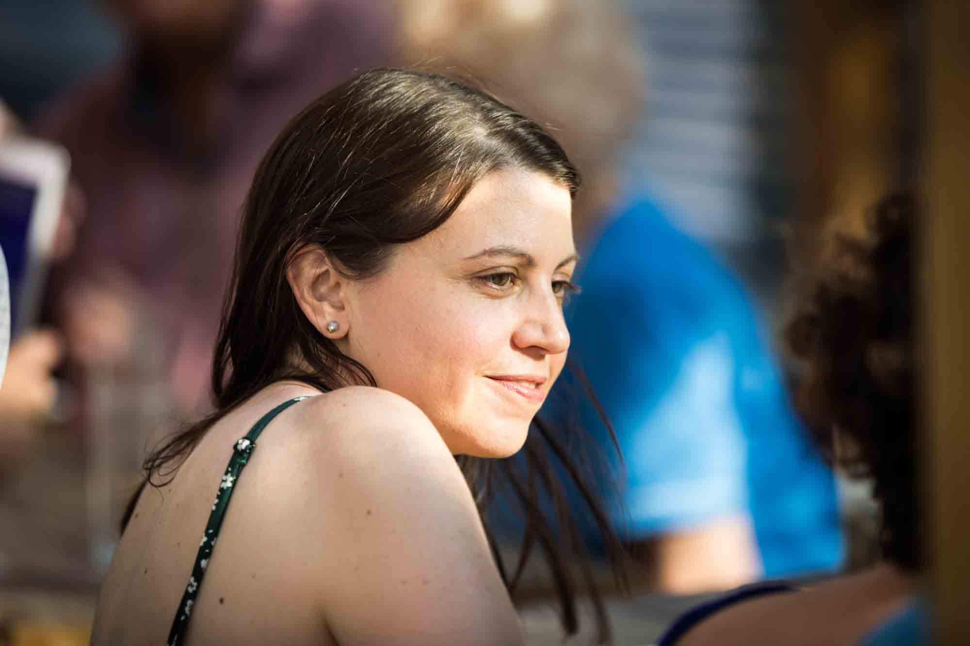 Woman with brown hair wearing sundress during rehearsal dinner at an outdoor restaurant