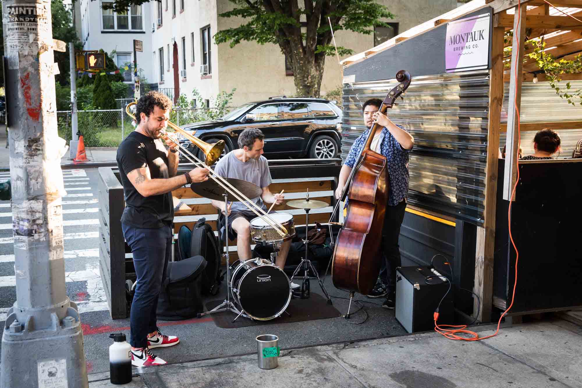 Jazz band playing on a sidewalk corner during rehearsal dinner at an outdoor restaurant