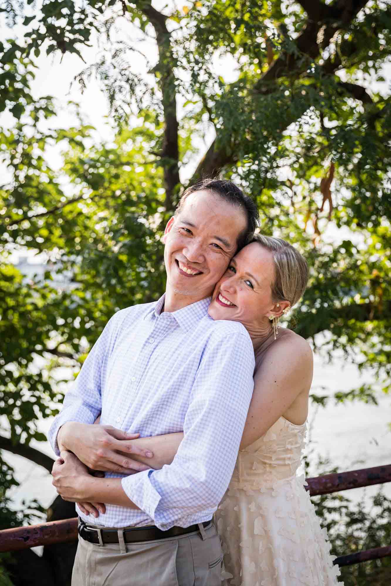 Astoria Park engagement photos of a couple hugging along waterfront