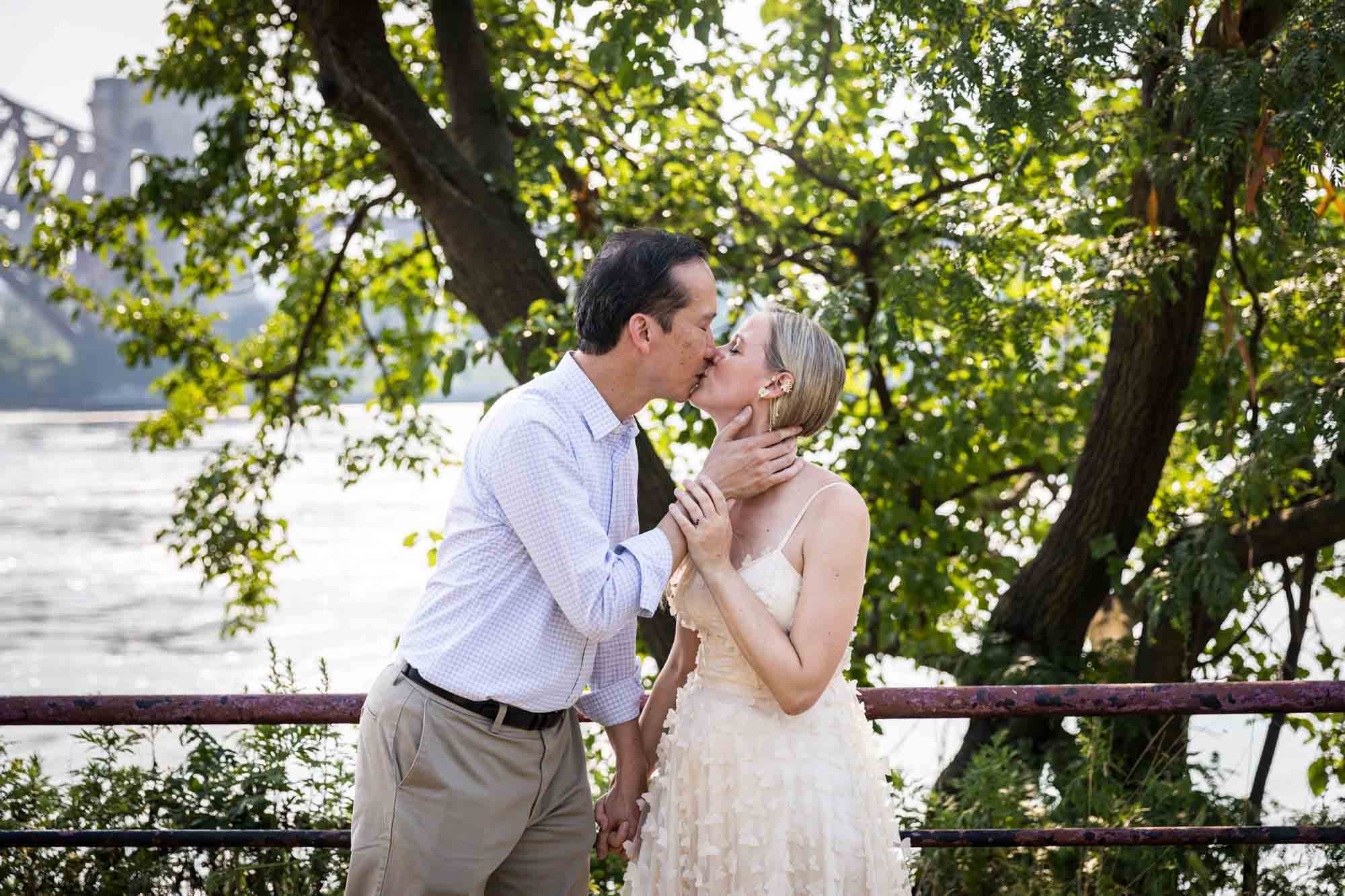 Astoria Park engagement photos of a couple kissing along waterfront