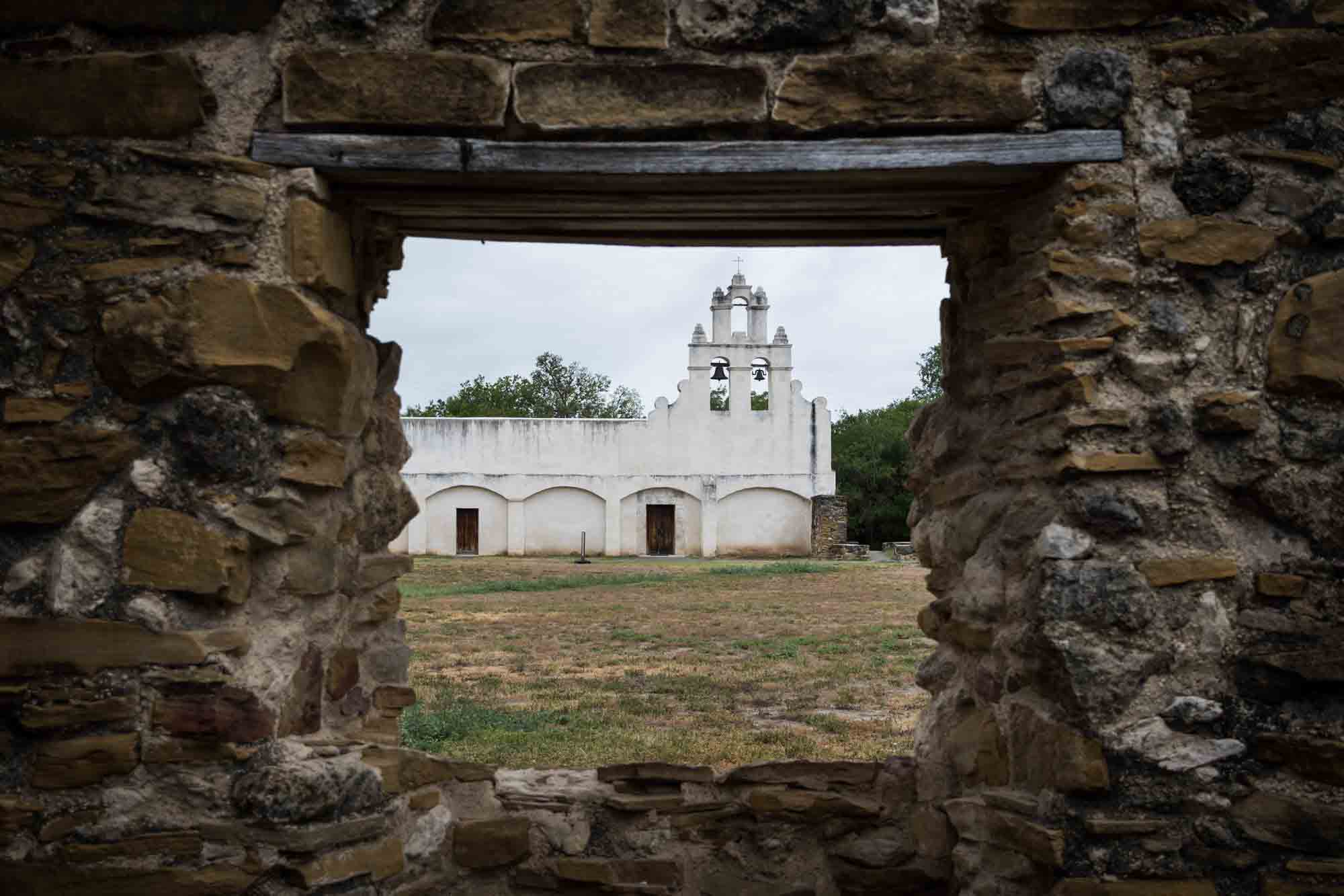 Church at Mission San Juan seen through a stone window in San Antonio