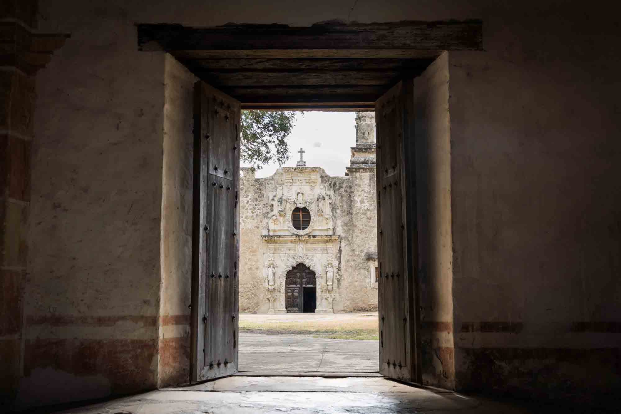 Facade of church in Mission San Juan seen through doorway in San Antonio