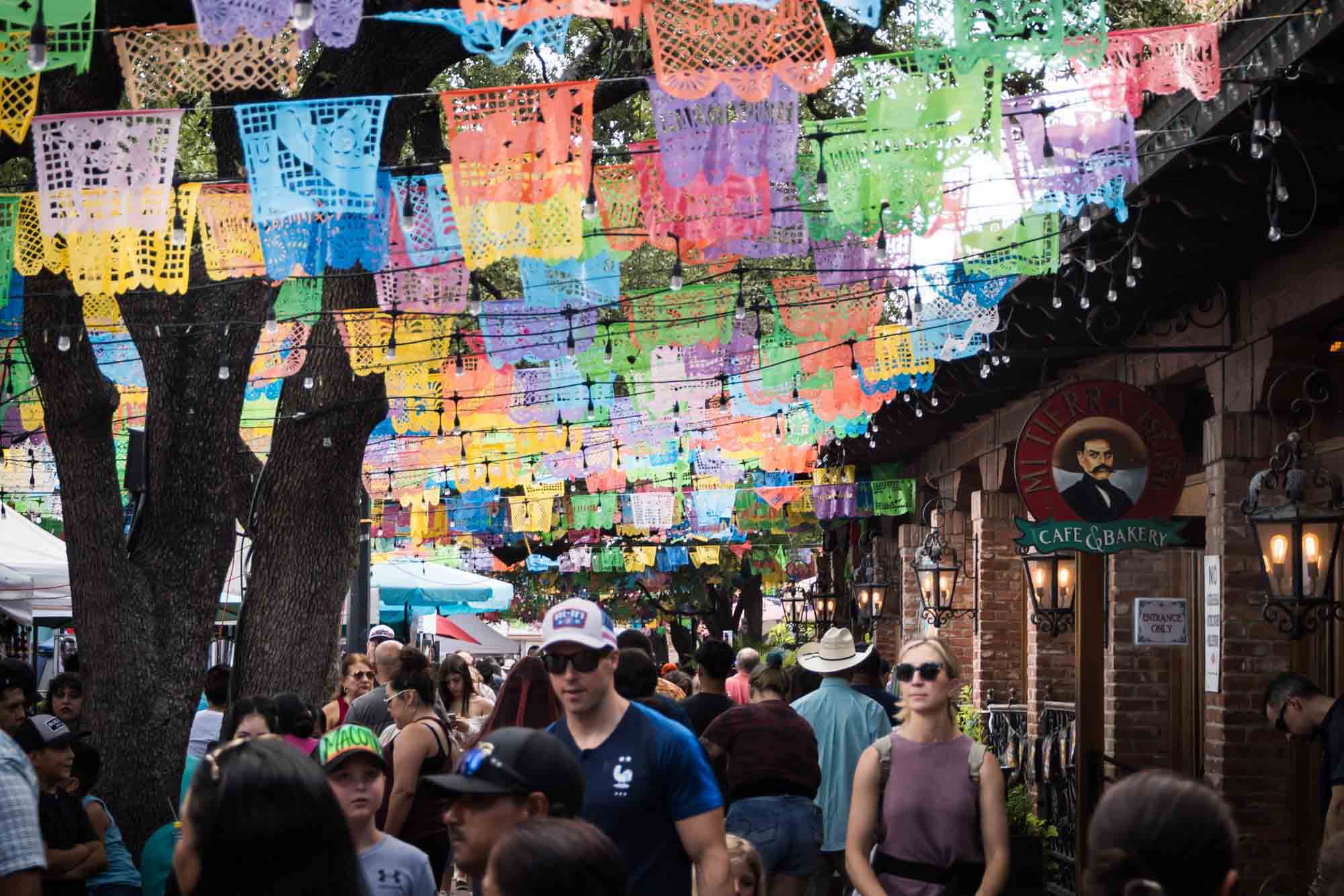 Colorful papel picabo hanging above crowds at the Mercado in San Antonio