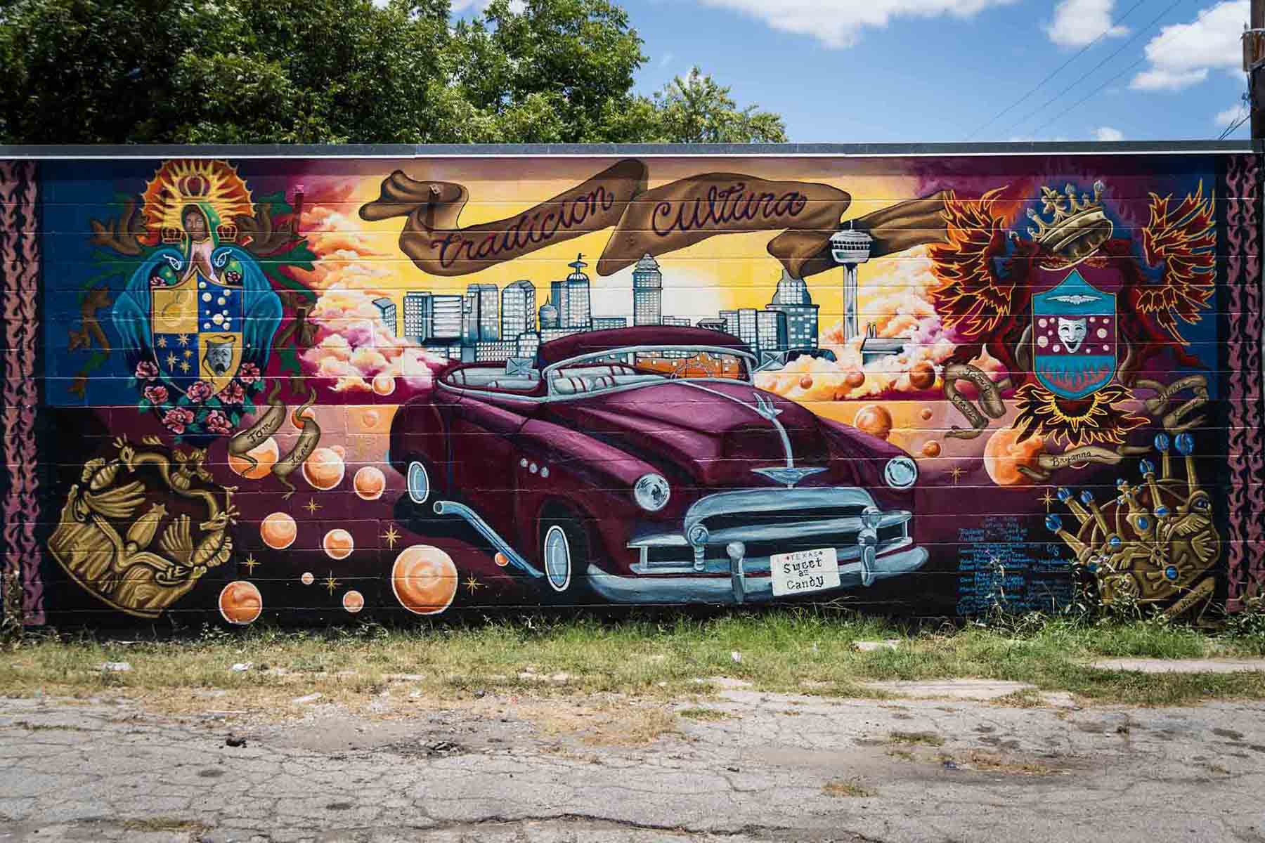 Colorful mural of car and religious imagery against wall in San Antonio