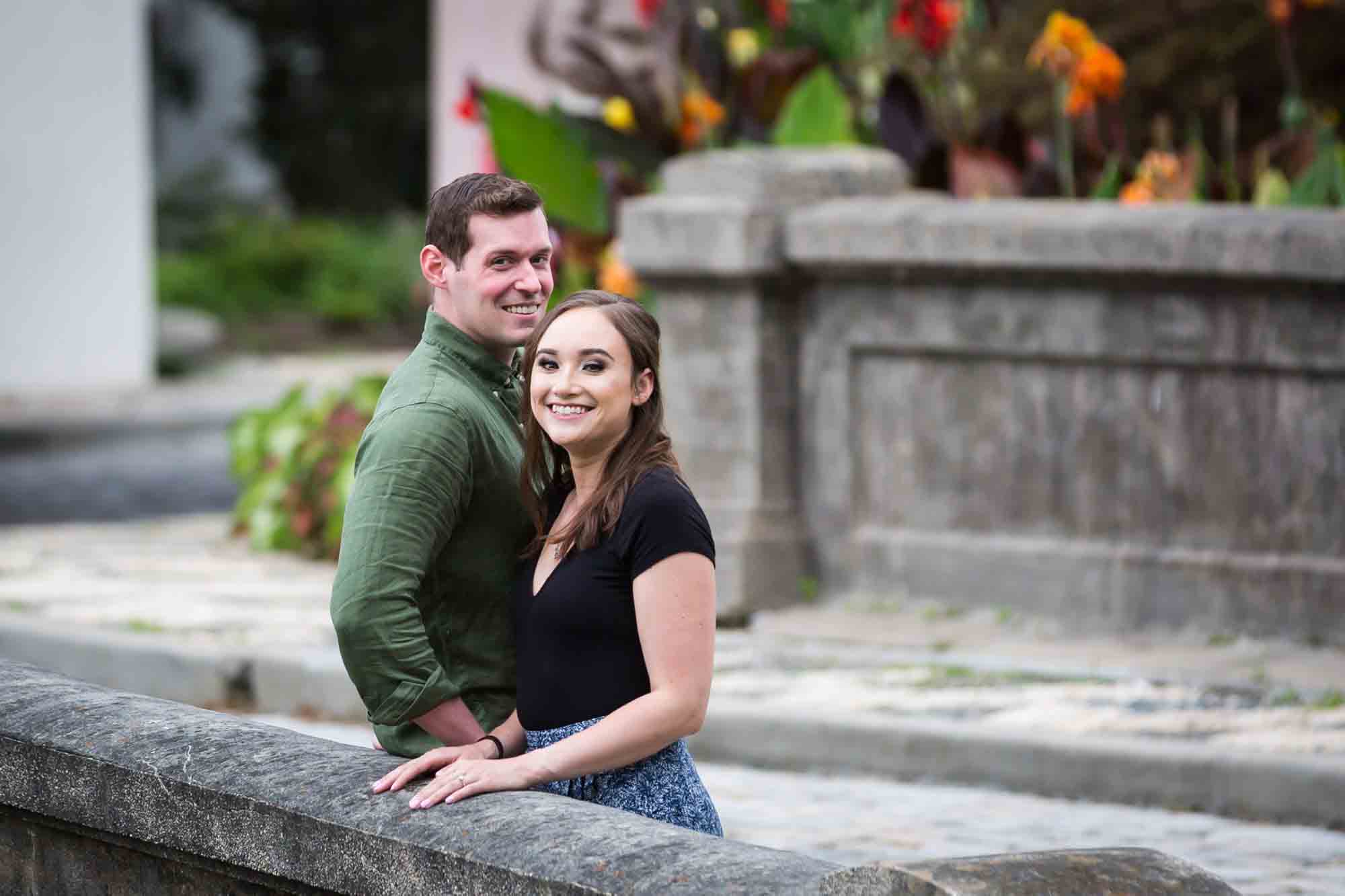 Vanderbilt Museum engagement photos of couple on bridge in front of stone gate