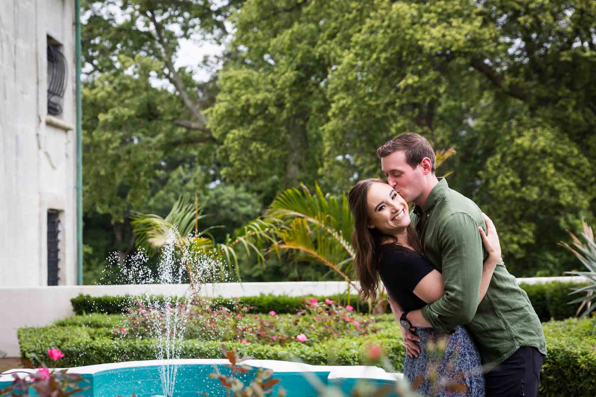 Man kissing woman on cheek in front of fountain at the Vanderbilt Museum