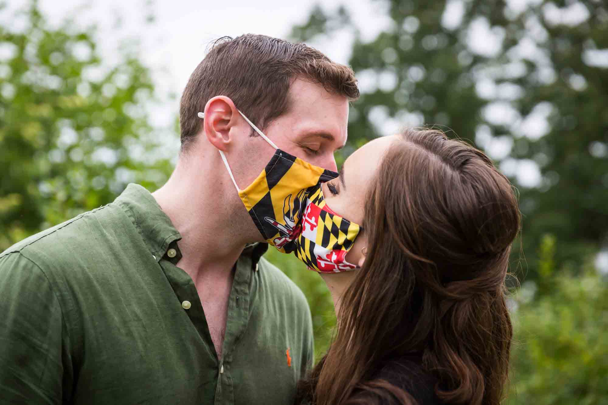 Vanderbilt Museum engagement photos of couple kissing with masks on