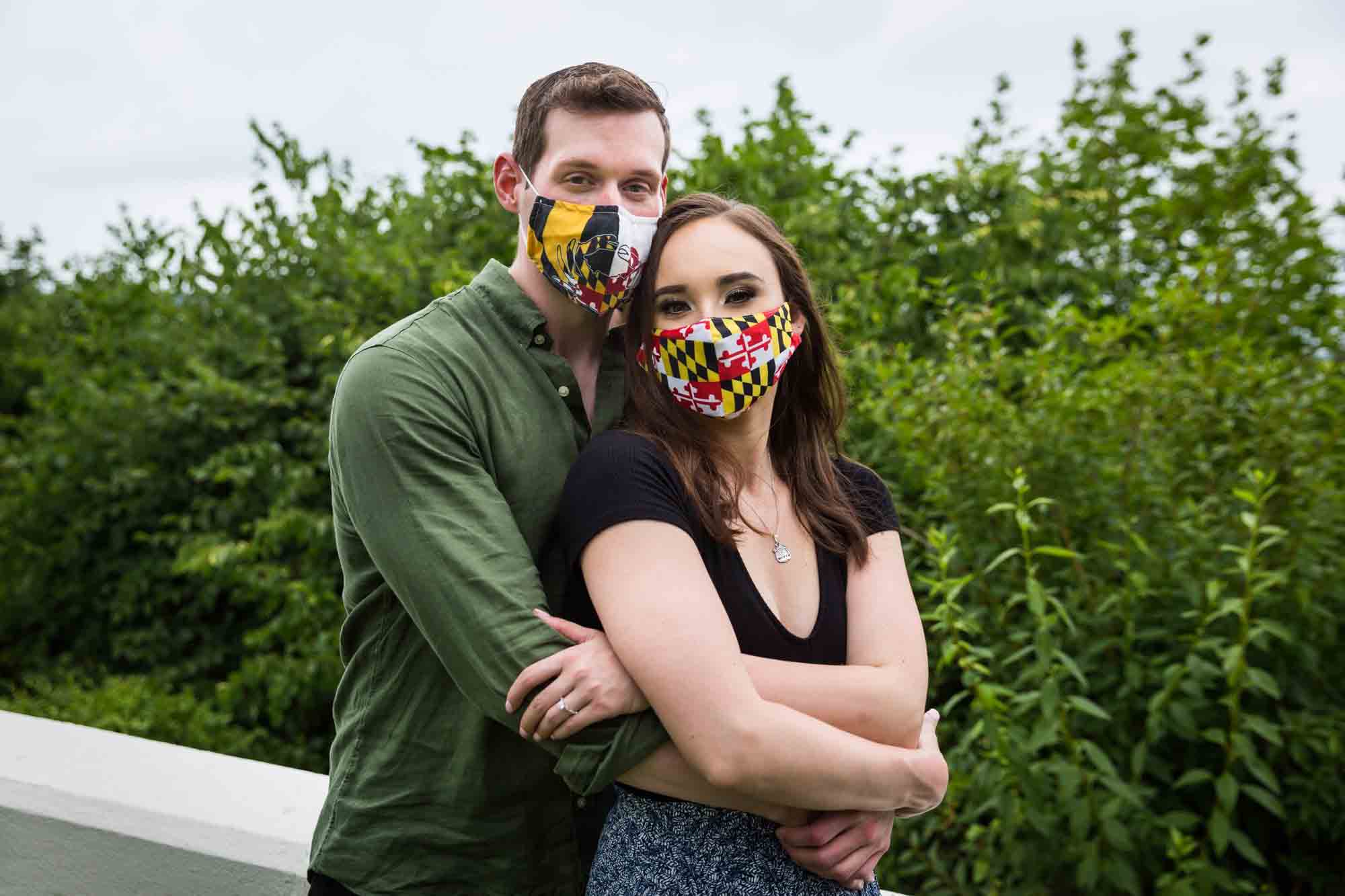 Vanderbilt Museum engagement photos of couple hugging while wearing face masks