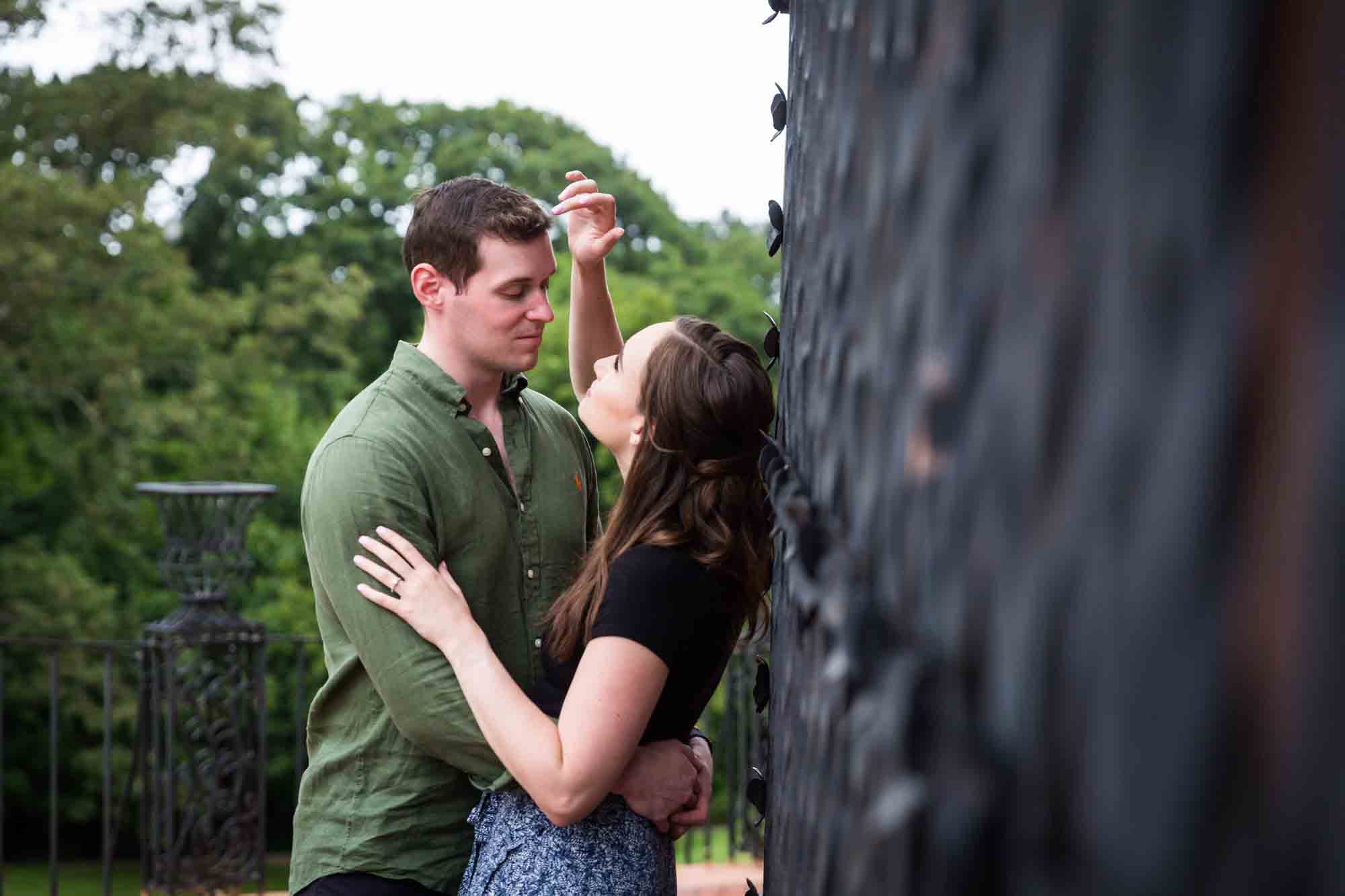 Woman touching man's hair along iron gate at the Vanderbilt Museum