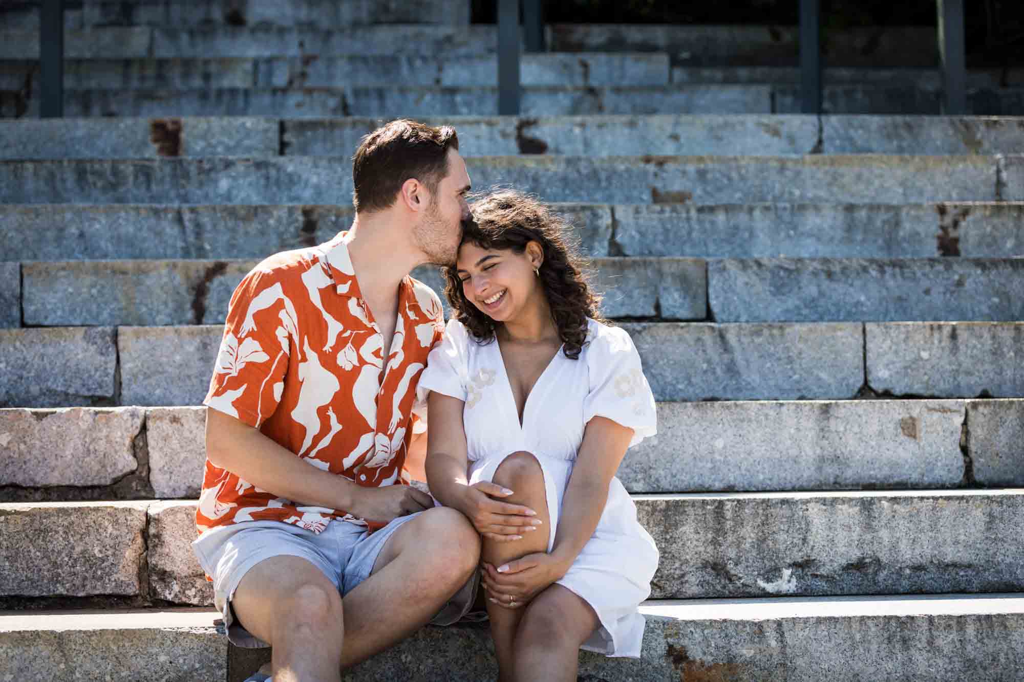 Man kissing woman on the head on Granite Steps in Brooklyn Bridge Park