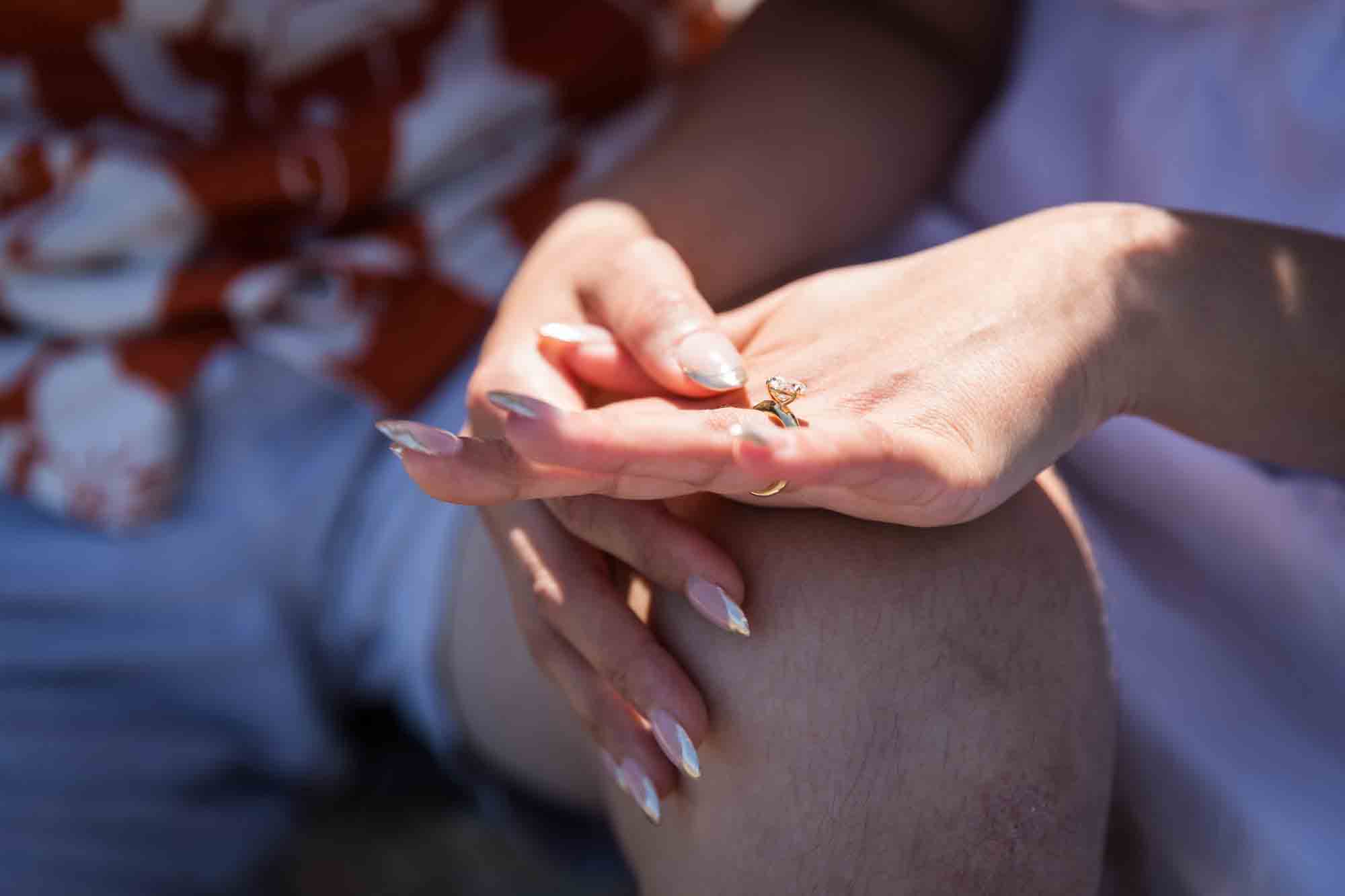 Close up of woman's hand showing oval engagement ring
