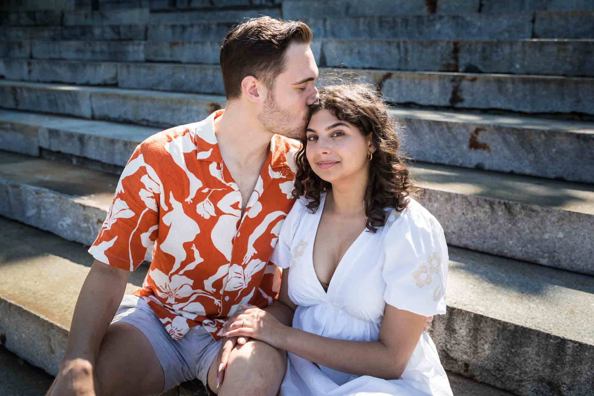 Man kissing woman on the head on Granite Steps in Brooklyn Bridge Park