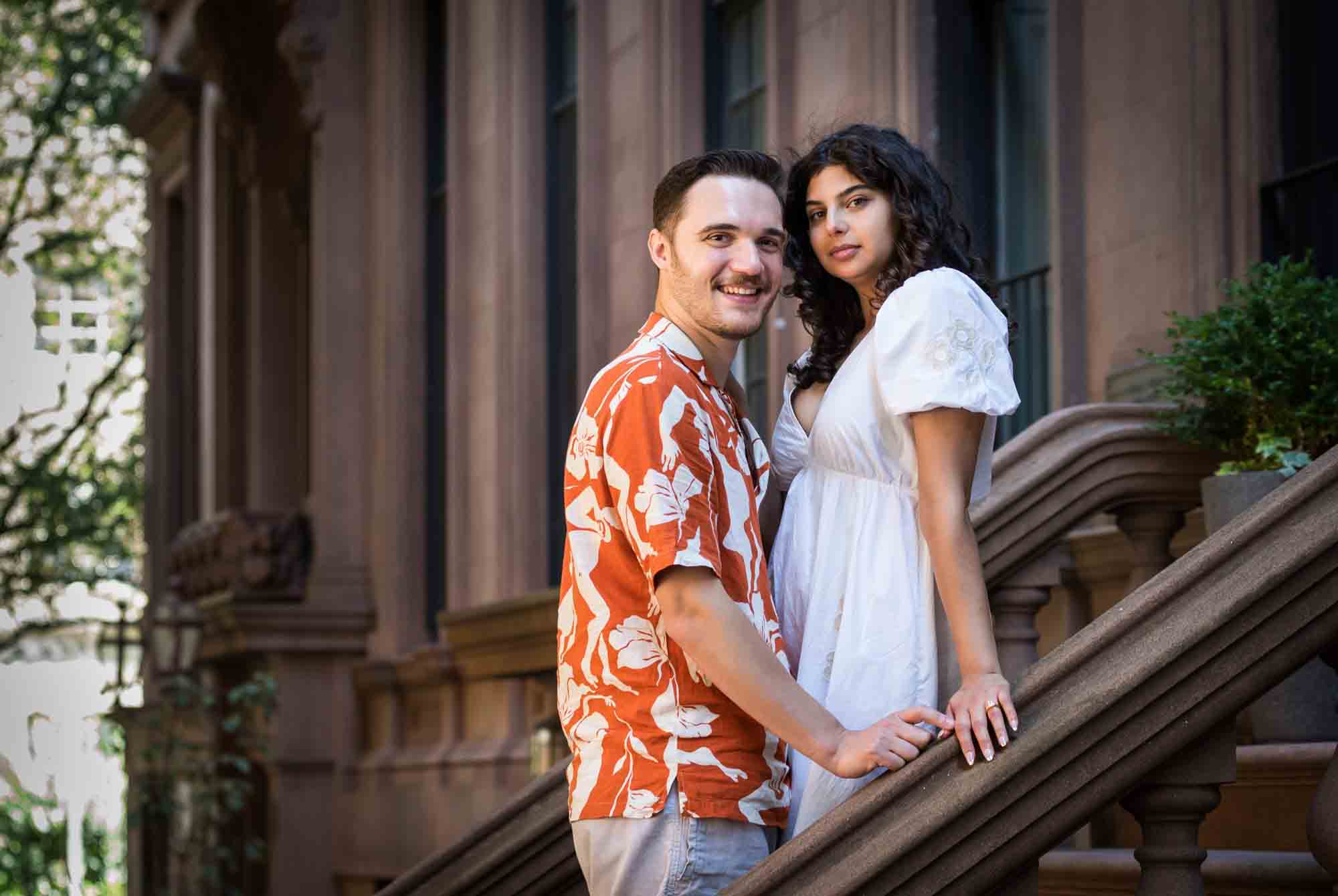 Couple standing on brownstone staircase during a Brooklyn Heights surprise proposal