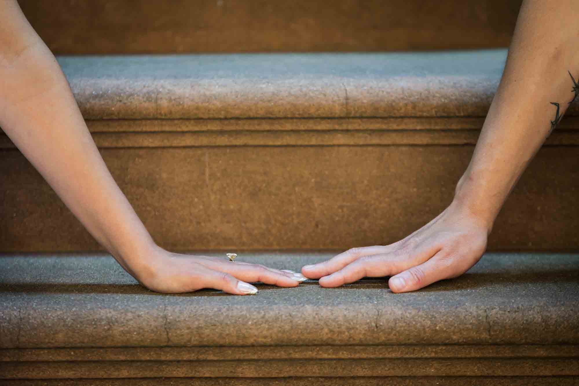 Close up of couple touching fingers on brownstone stairs
