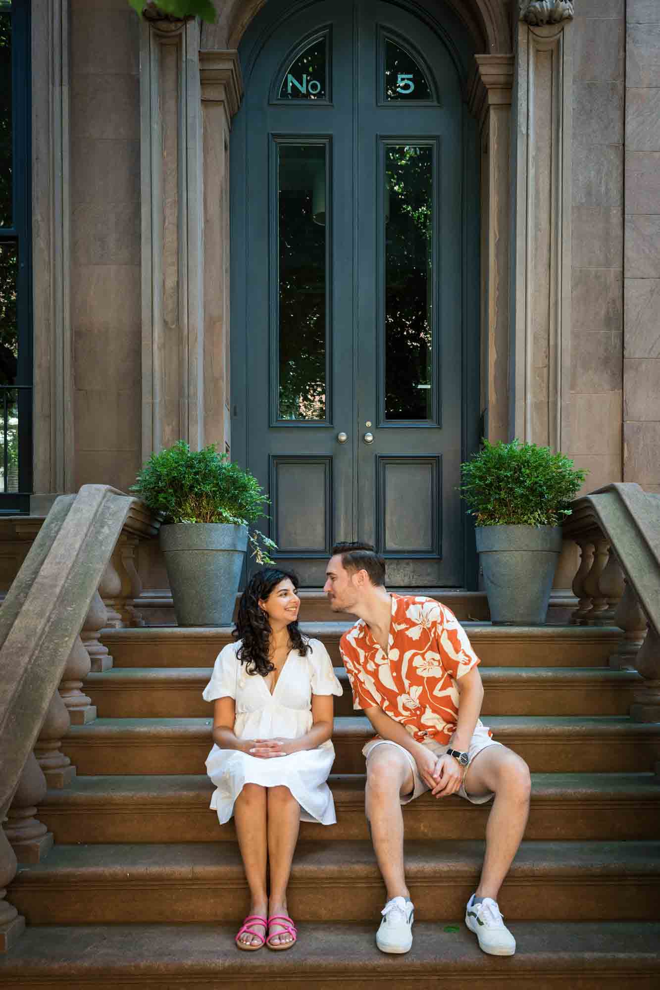 Couple about to kiss on brownstone staircase during a Brooklyn Heights surprise proposal