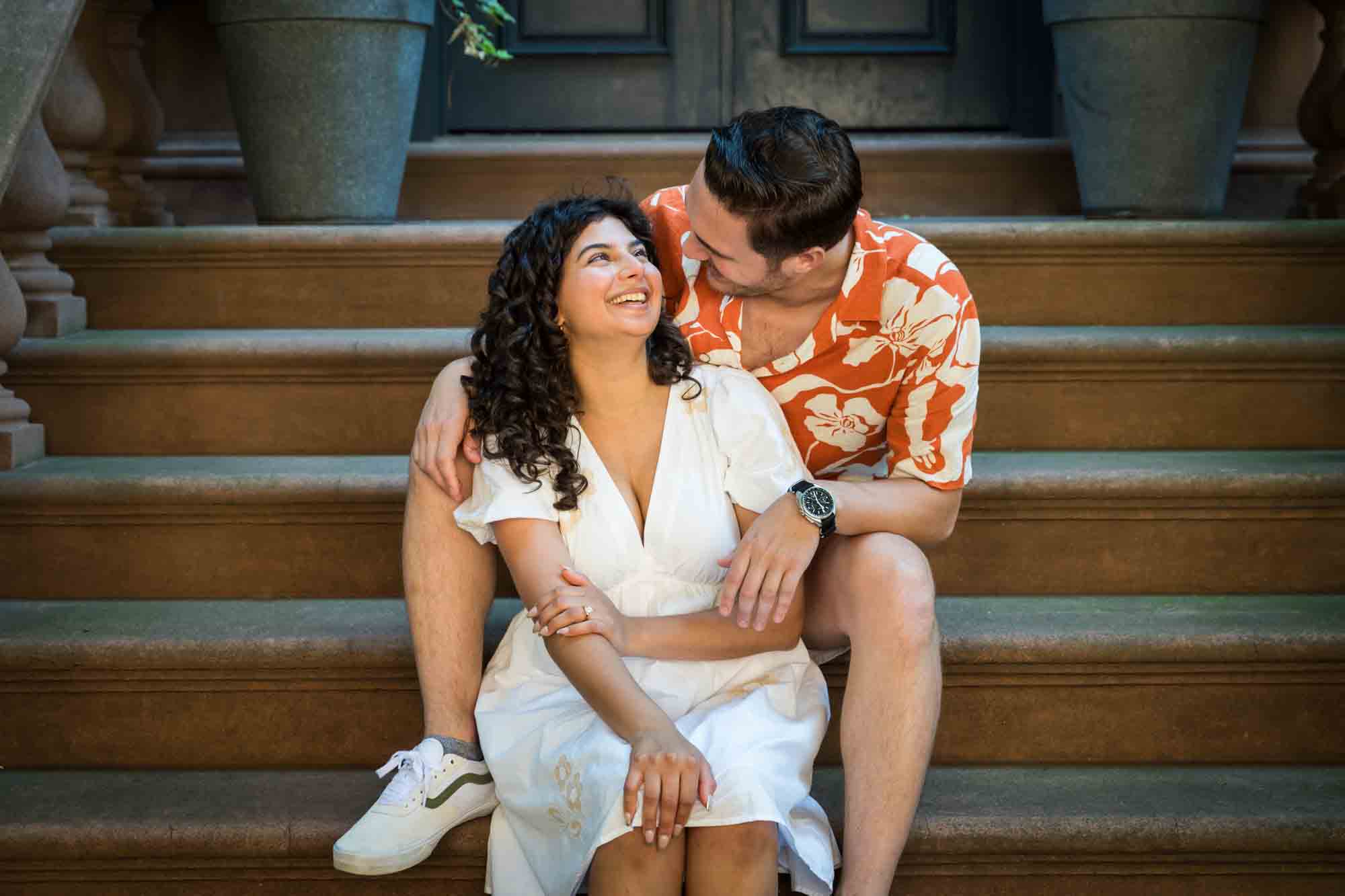 Couple looking at each other on brownstone staircase during a Brooklyn Heights surprise proposal