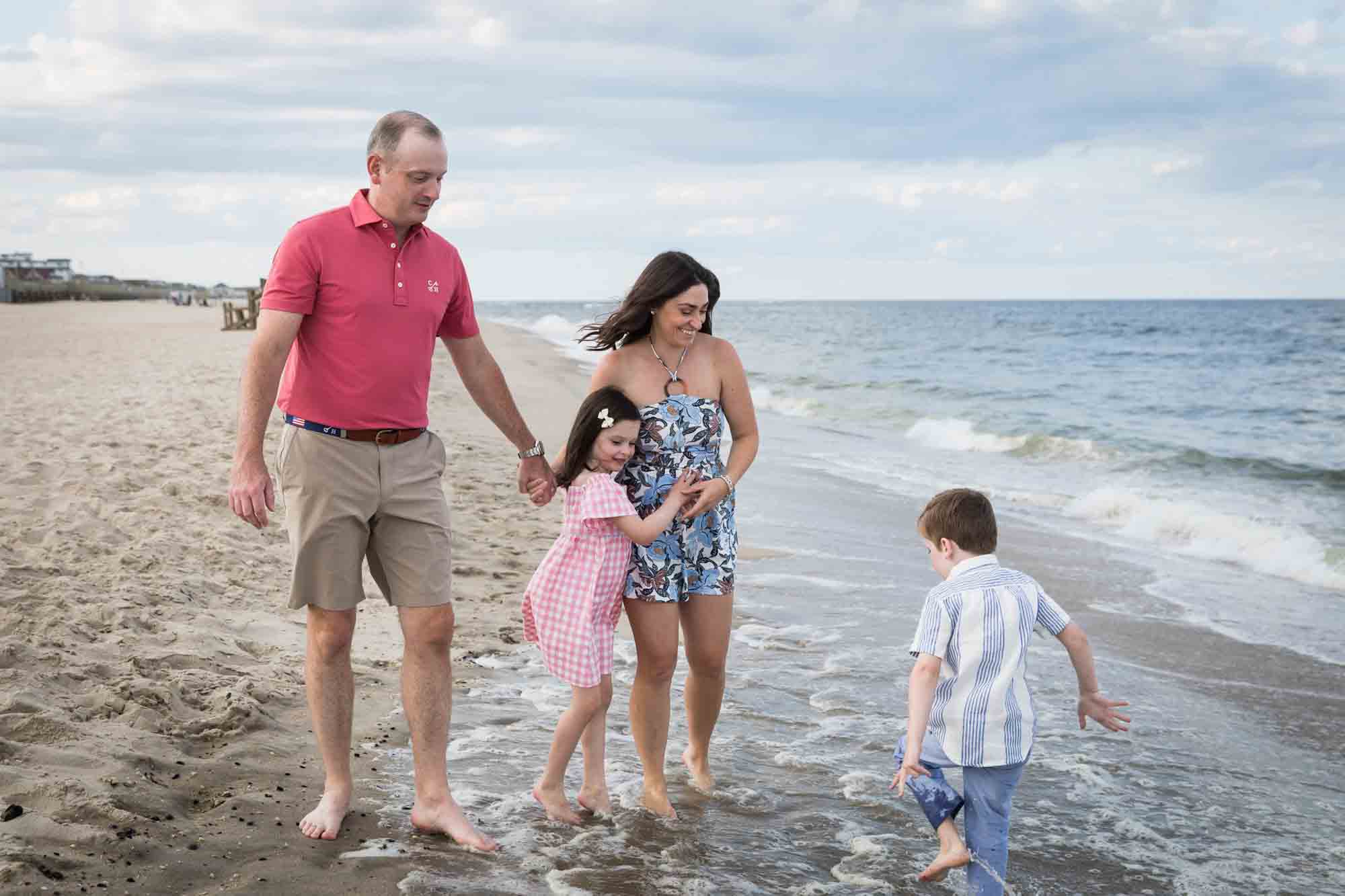 Parents and two kids playing on the beach for an article on how to get the best beach photos