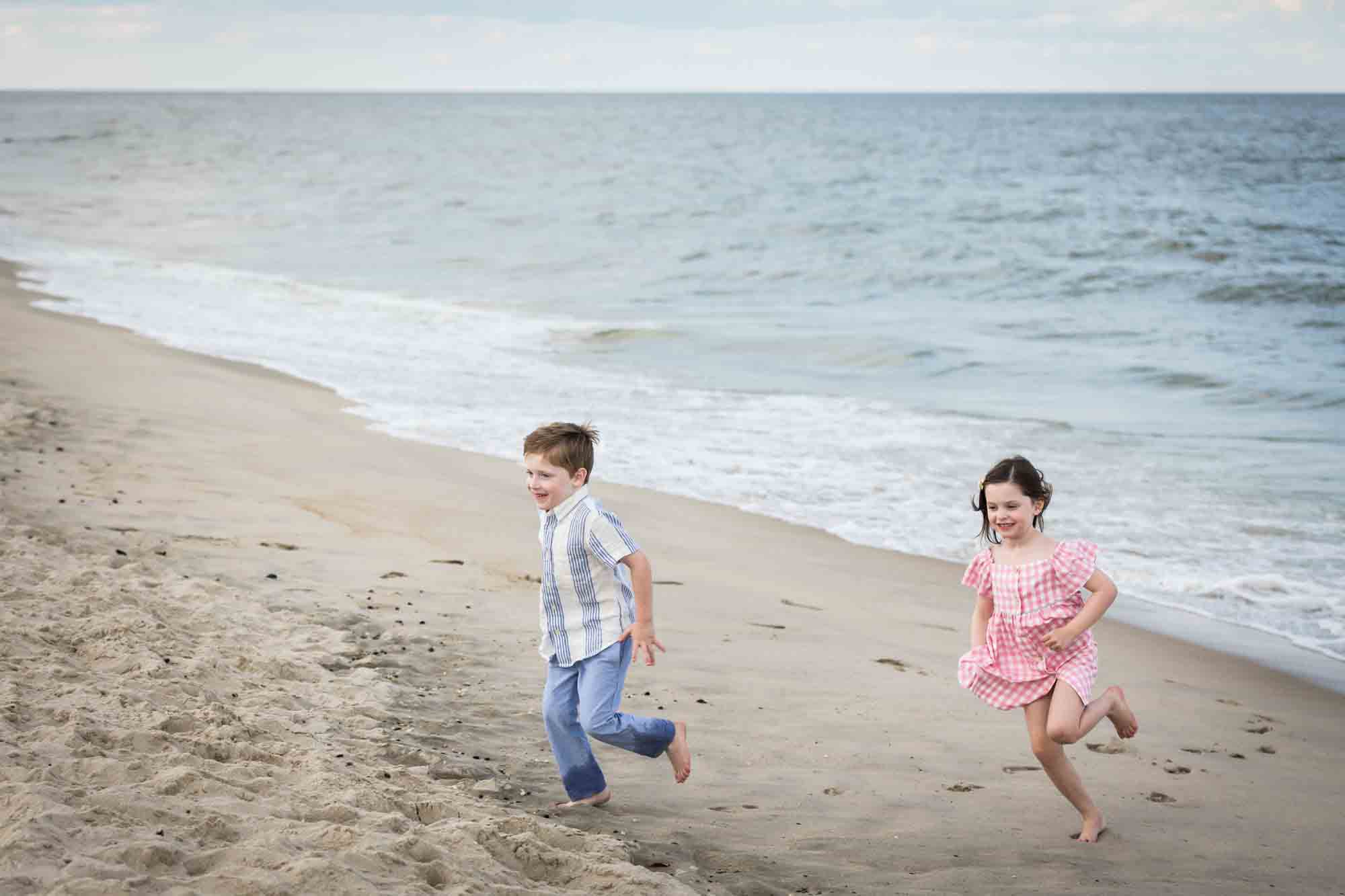 Two kids playing on the beach in front of ocean for an article on how to get the best beach photos