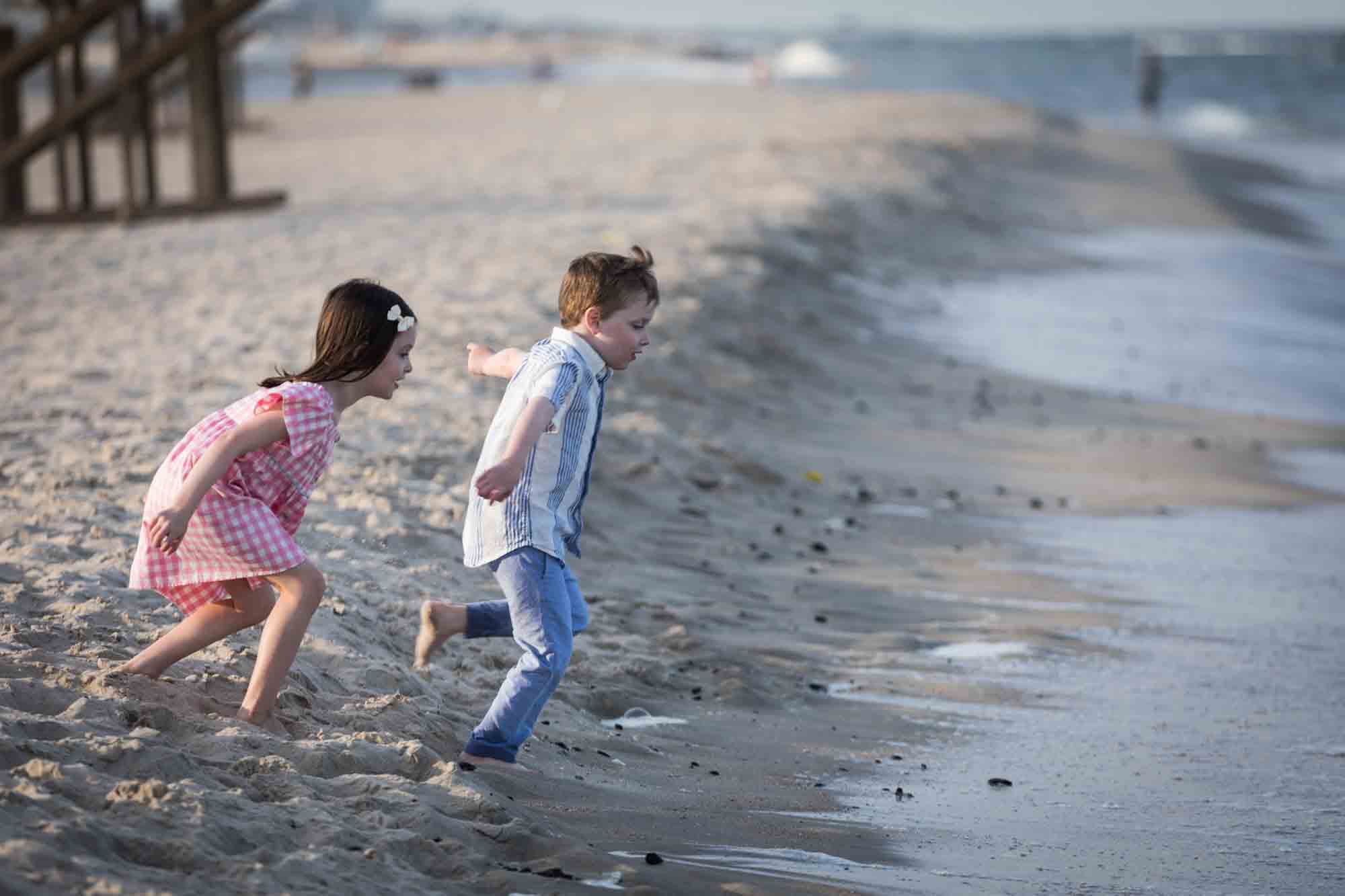 Two kids playing on the beach in front of ocean for an article on how to get the best beach photos