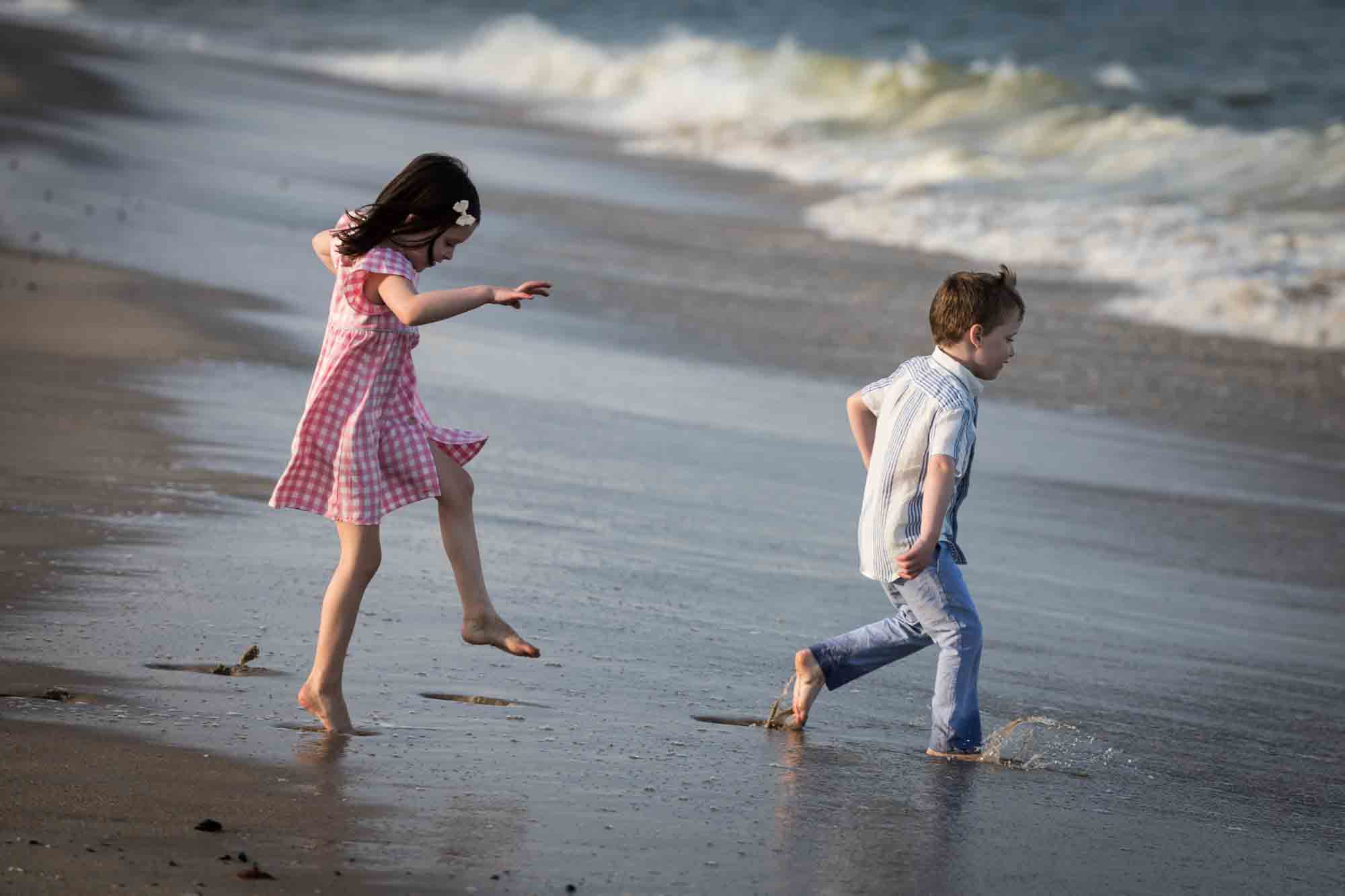 Two kids playing on the beach in front of ocean for an article on how to get the best beach photos