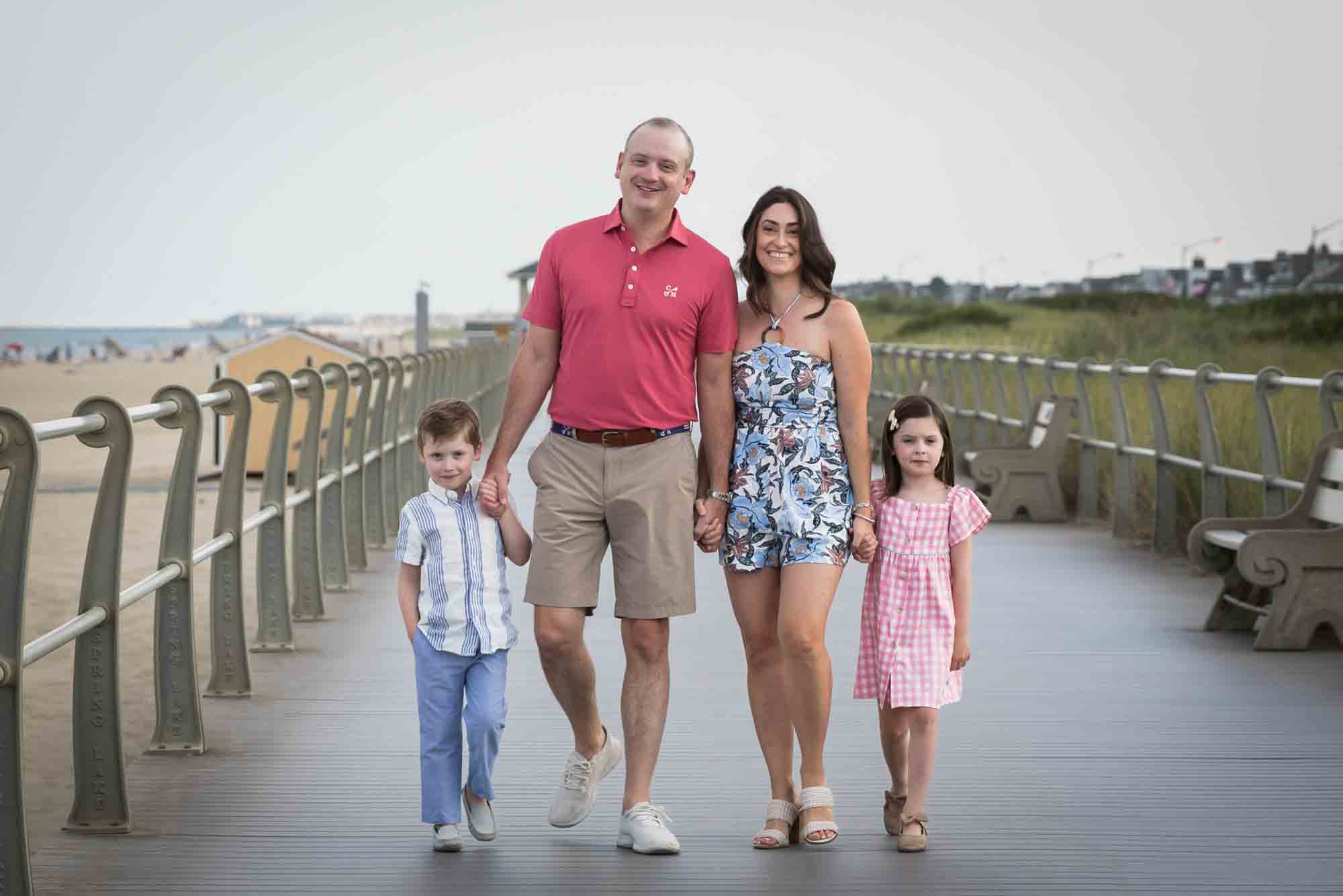 Parents and two kids walking on boardwalk in Spring Lake, NJ for an article on how to get the best beach photos