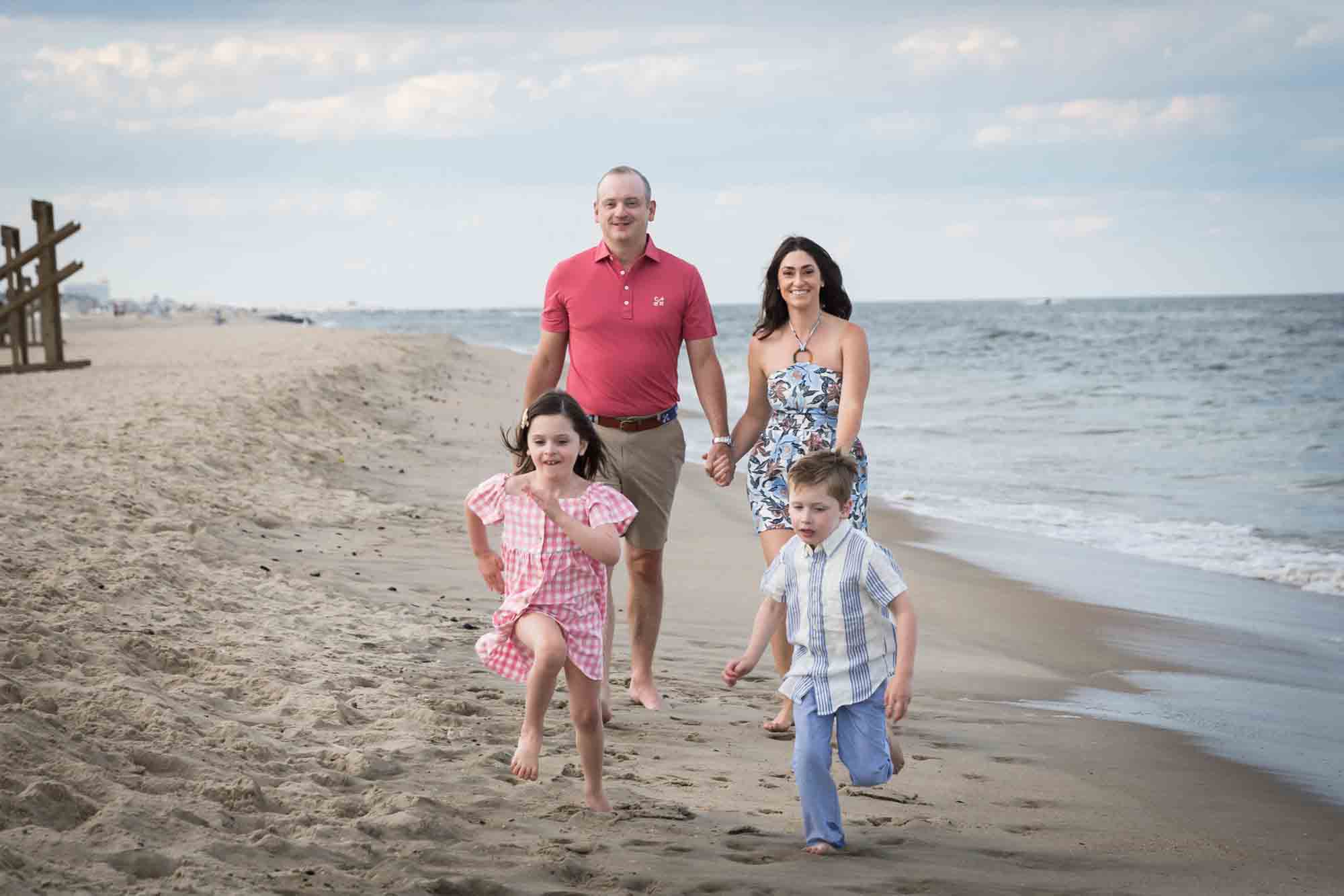 Parents and two kids walking on the beach for an article on how to get the best beach photos