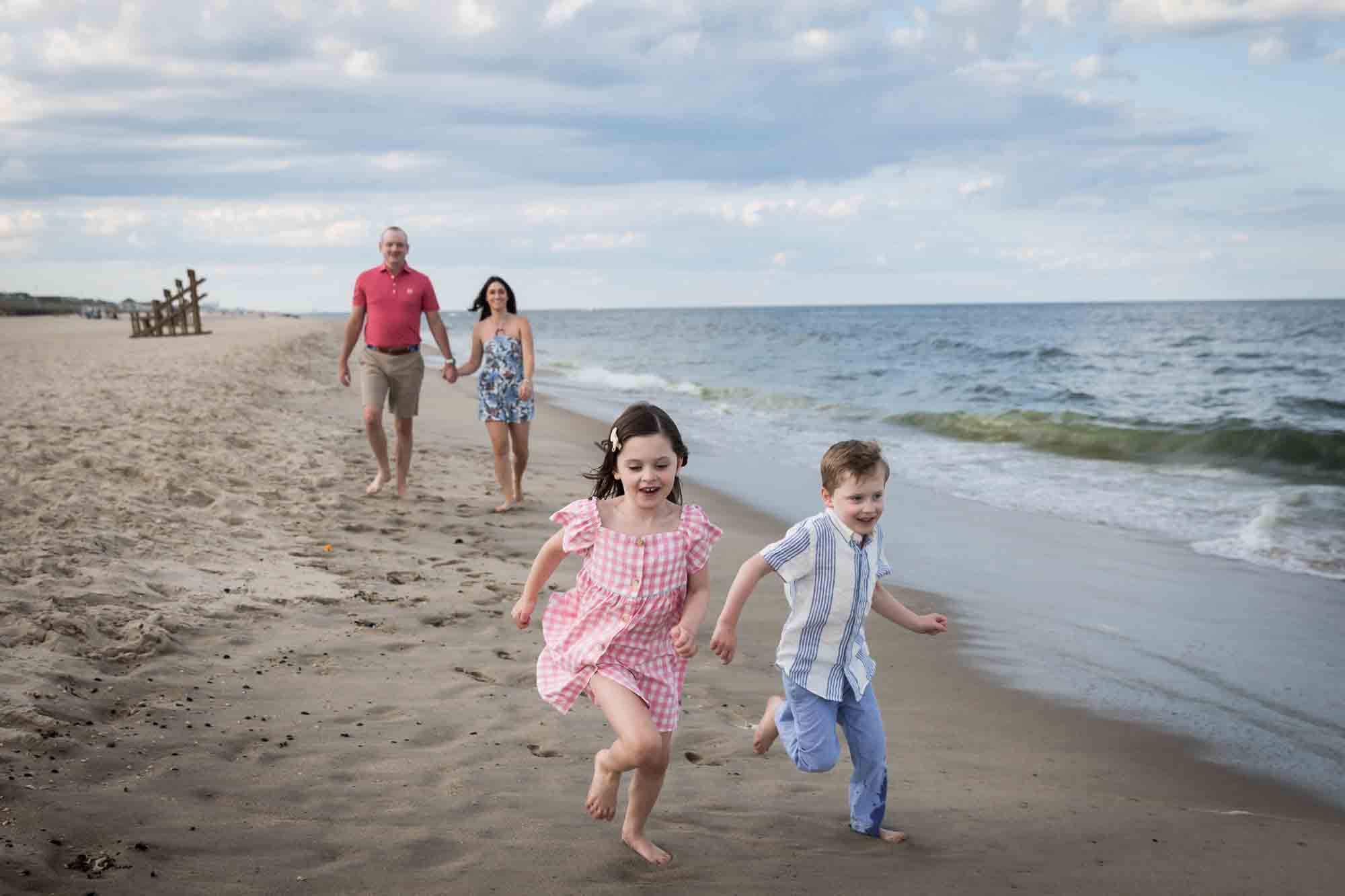 Parents and two kids walking on the beach for an article on how to get the best beach photos