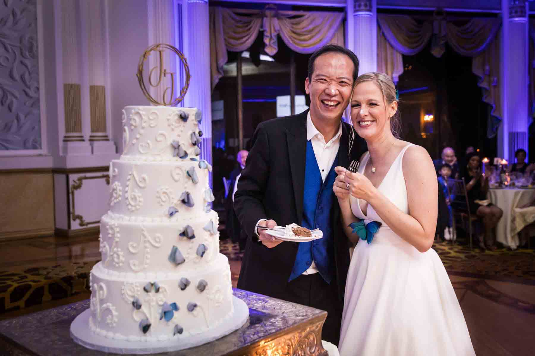 Bride and groom posing with icing on their noses in front of cake at a Terrace on the Park wedding