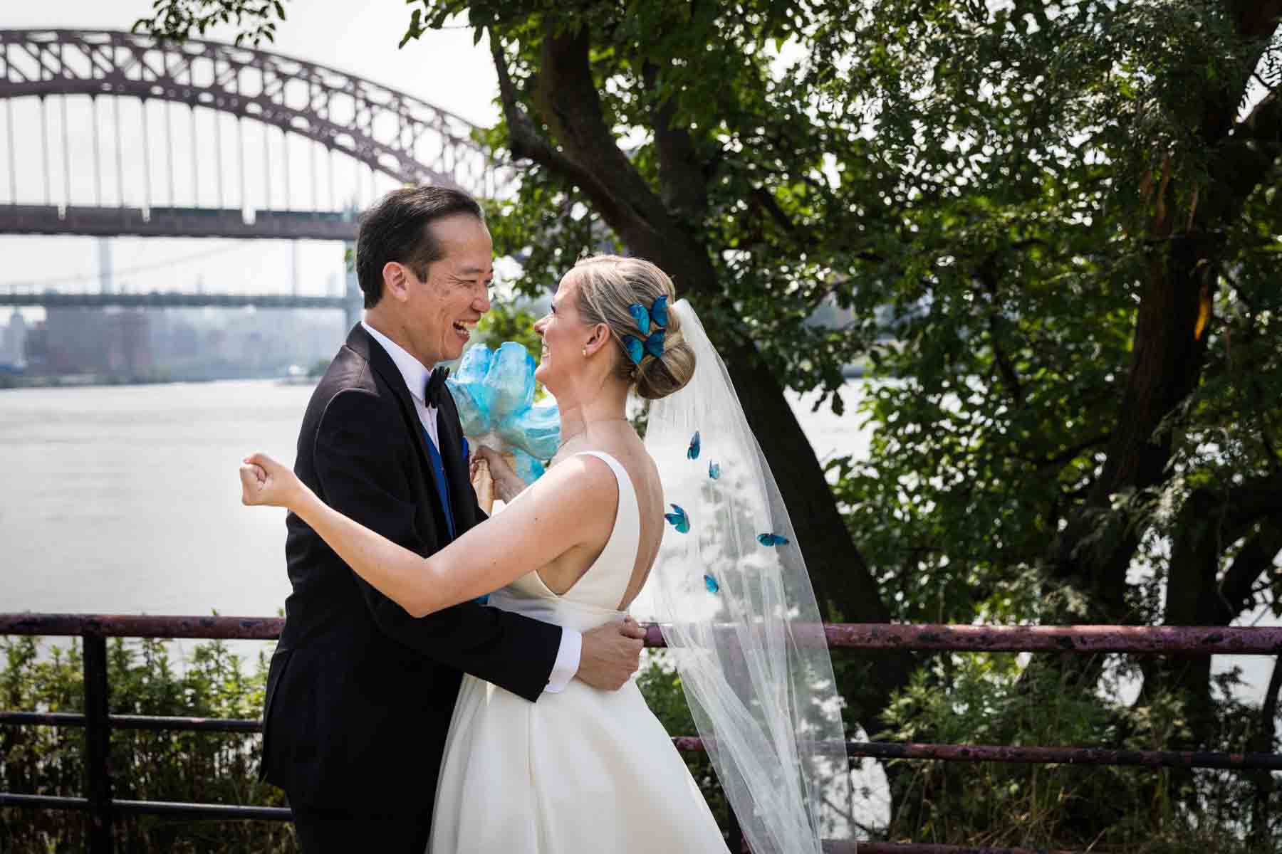 Bride and groom excited after first look along waterfront in Astoria Park