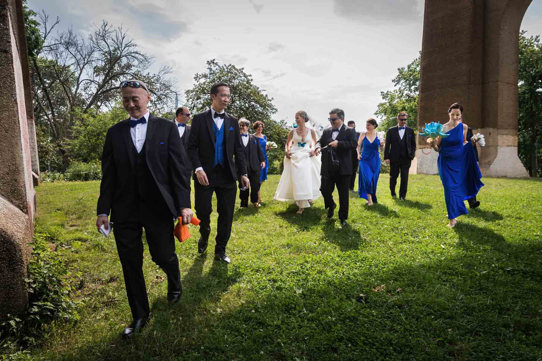 Bride, groom, and bridal party walking in Astoria Park