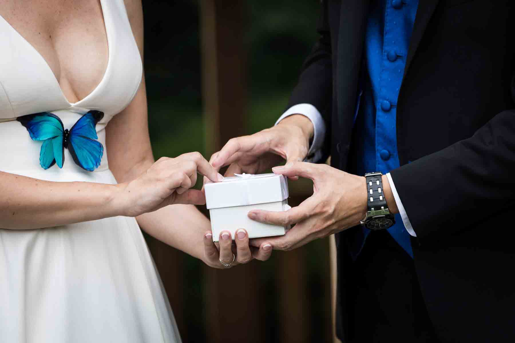 Close up of bride and groom with hands on white box