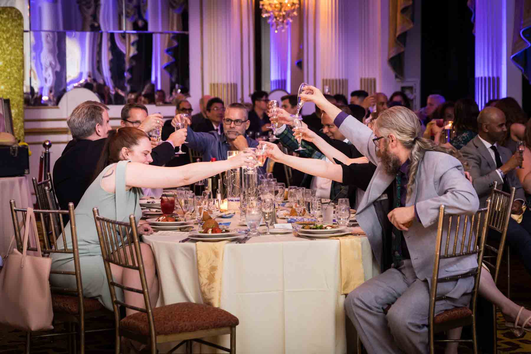 Guests at a table clinking glasses after a speech at a Terrace on the Park wedding