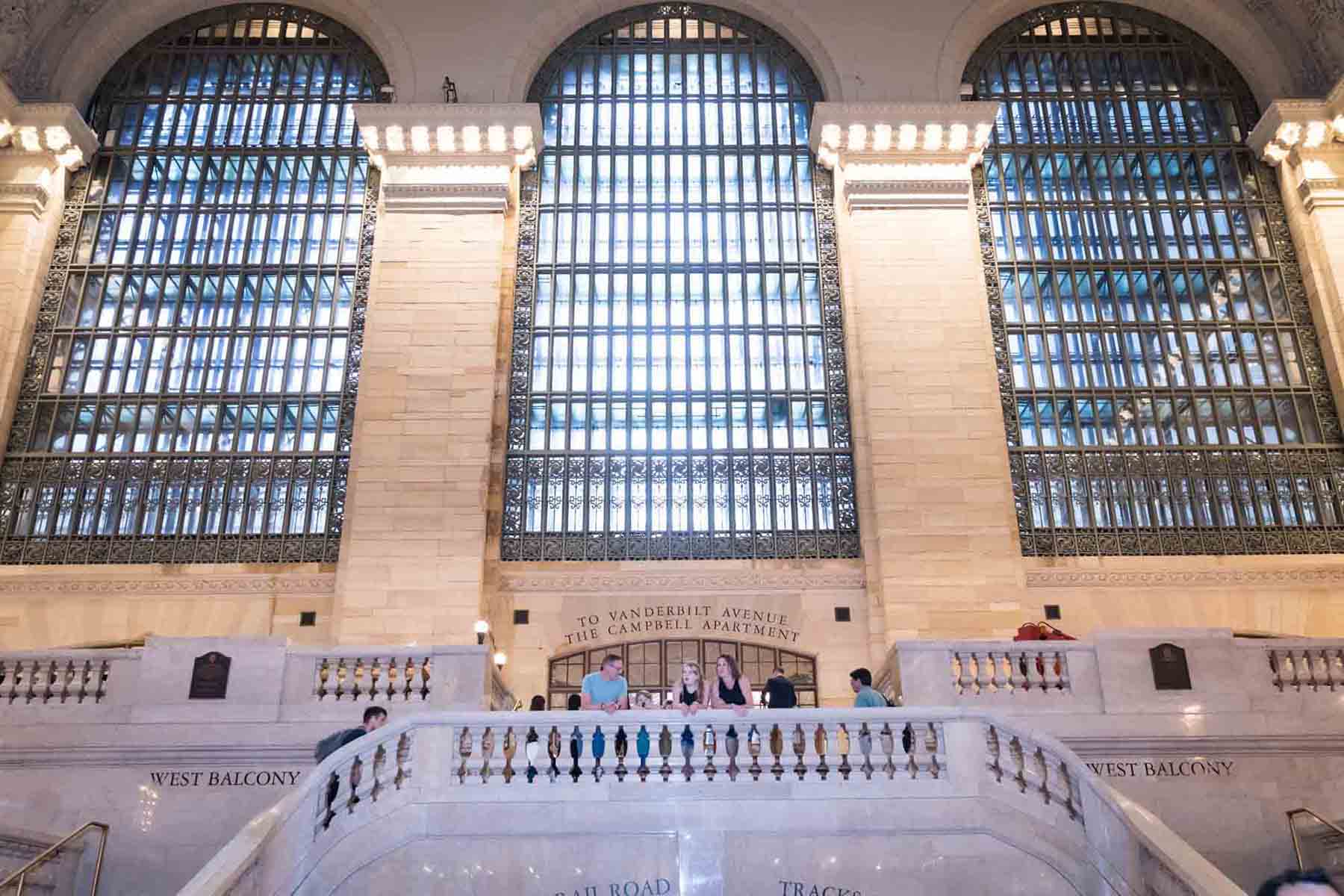 Family on stair case in front of large windows of Grand Central Terminal