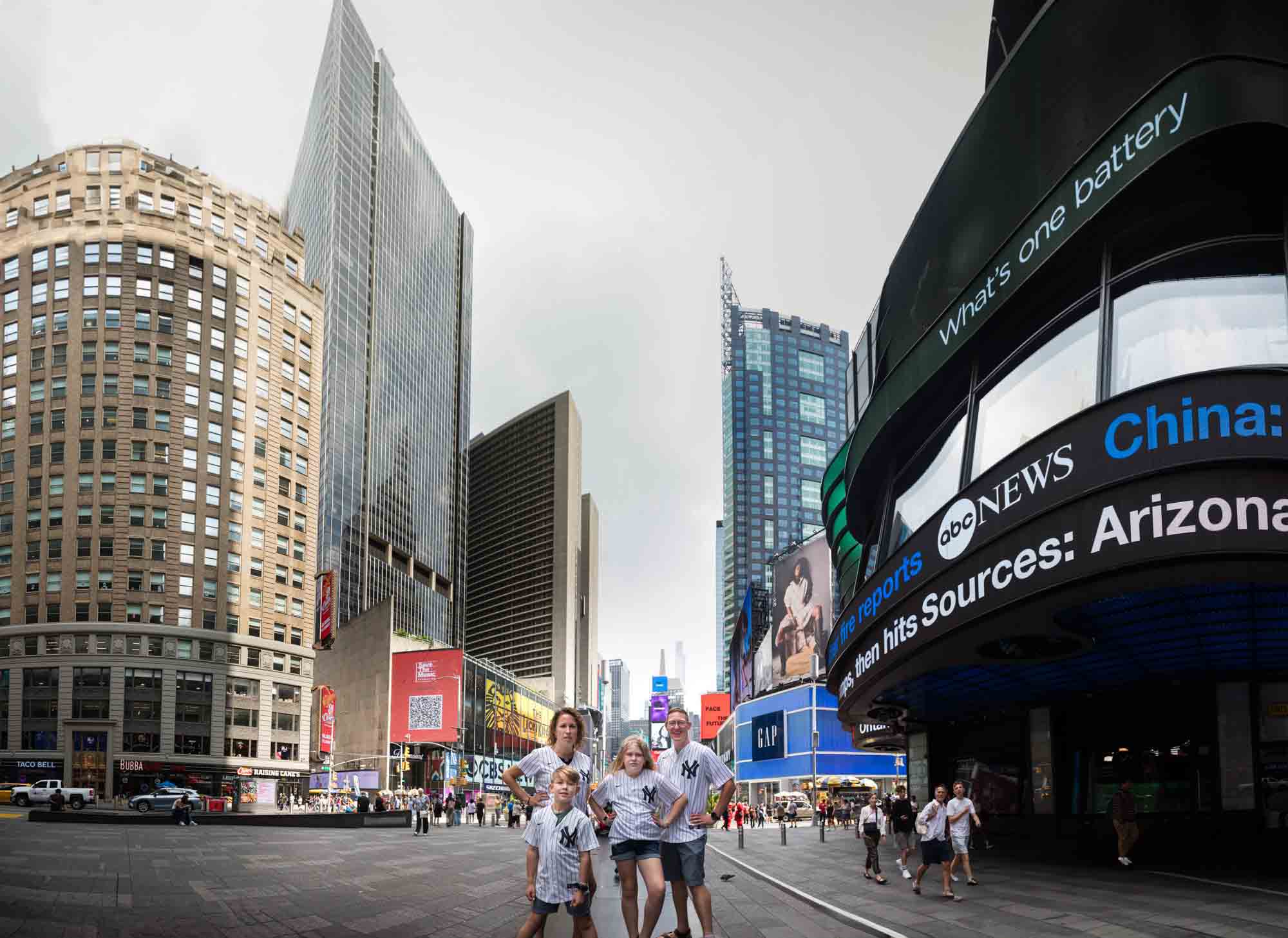 Parents and two kids wearing Yankees jerseys in Times Square for an article on best Manhattan family portrait locations