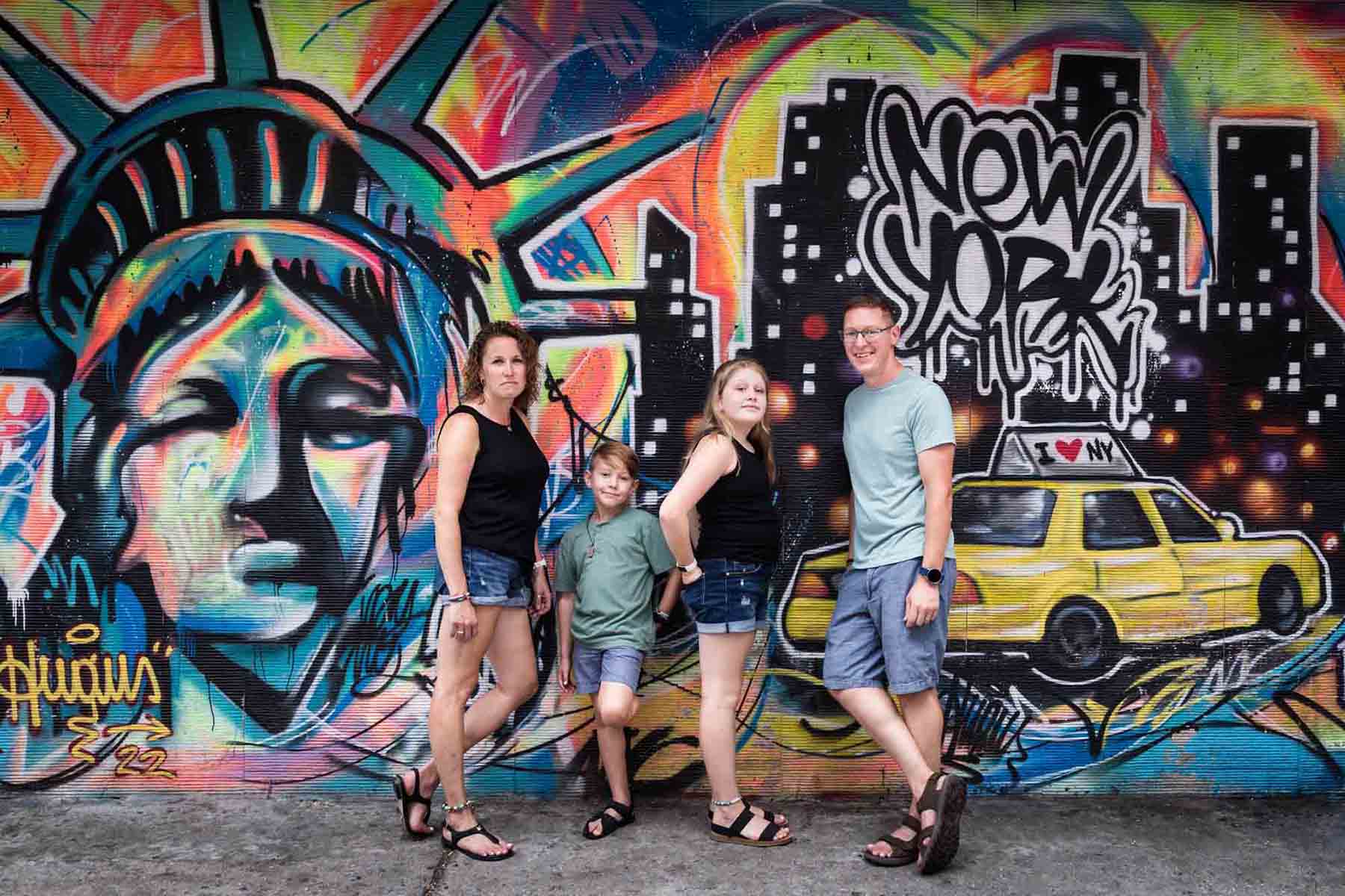 Parents and two kids standing in front of colorful graffiti mural for an article on best Manhattan family portrait locations
