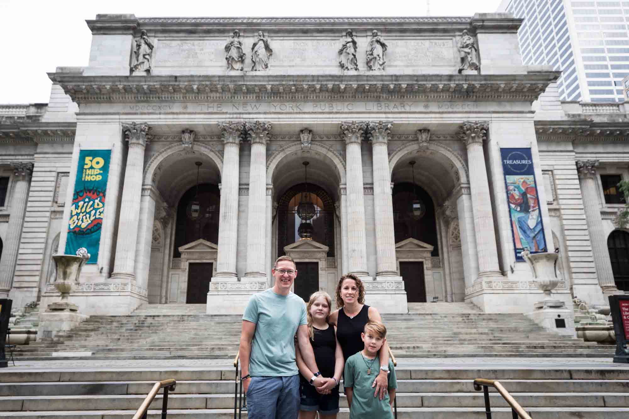 Parents and two kids standing together in front of New York Public Library for an article on best Manhattan family portrait locations