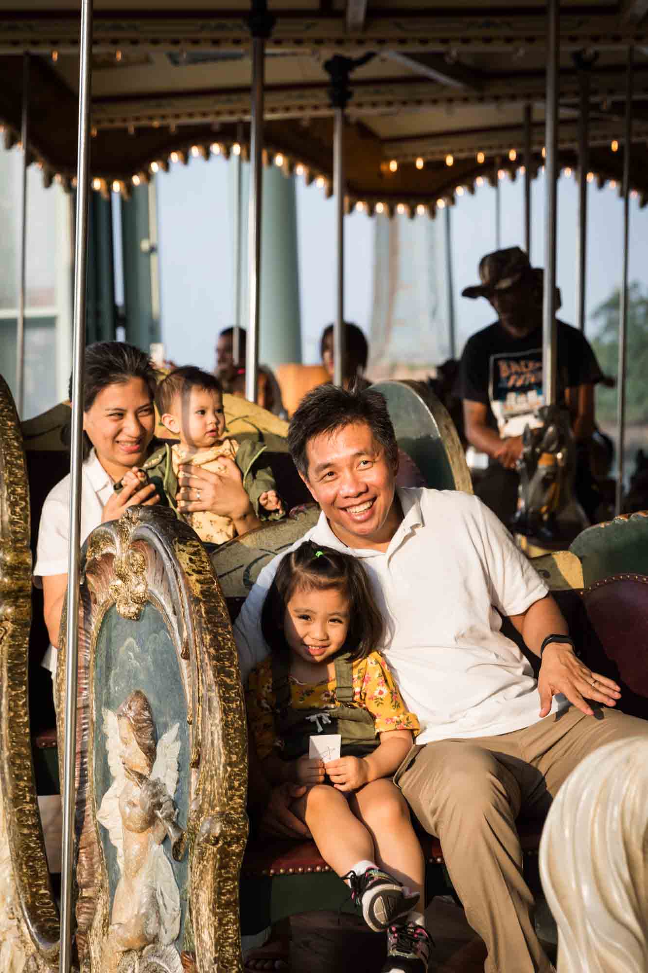 Parents with young daughters in carriage on Jane's Carousel in Brooklyn Bridge Park
