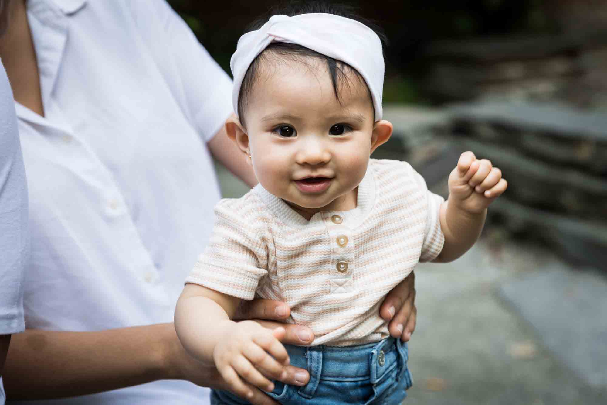 Baby girl wearing white headband and denim skirt