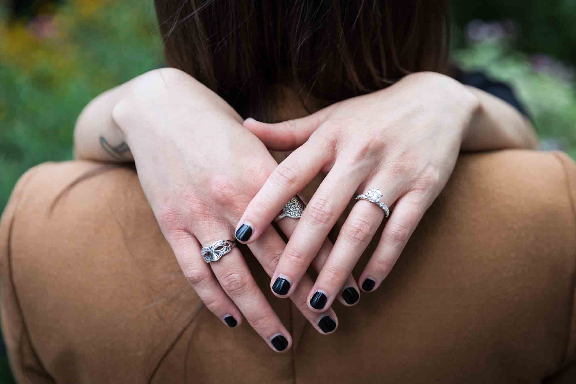 Close up of women's hands around the back of another woman's woman's neck showing off engagement ring