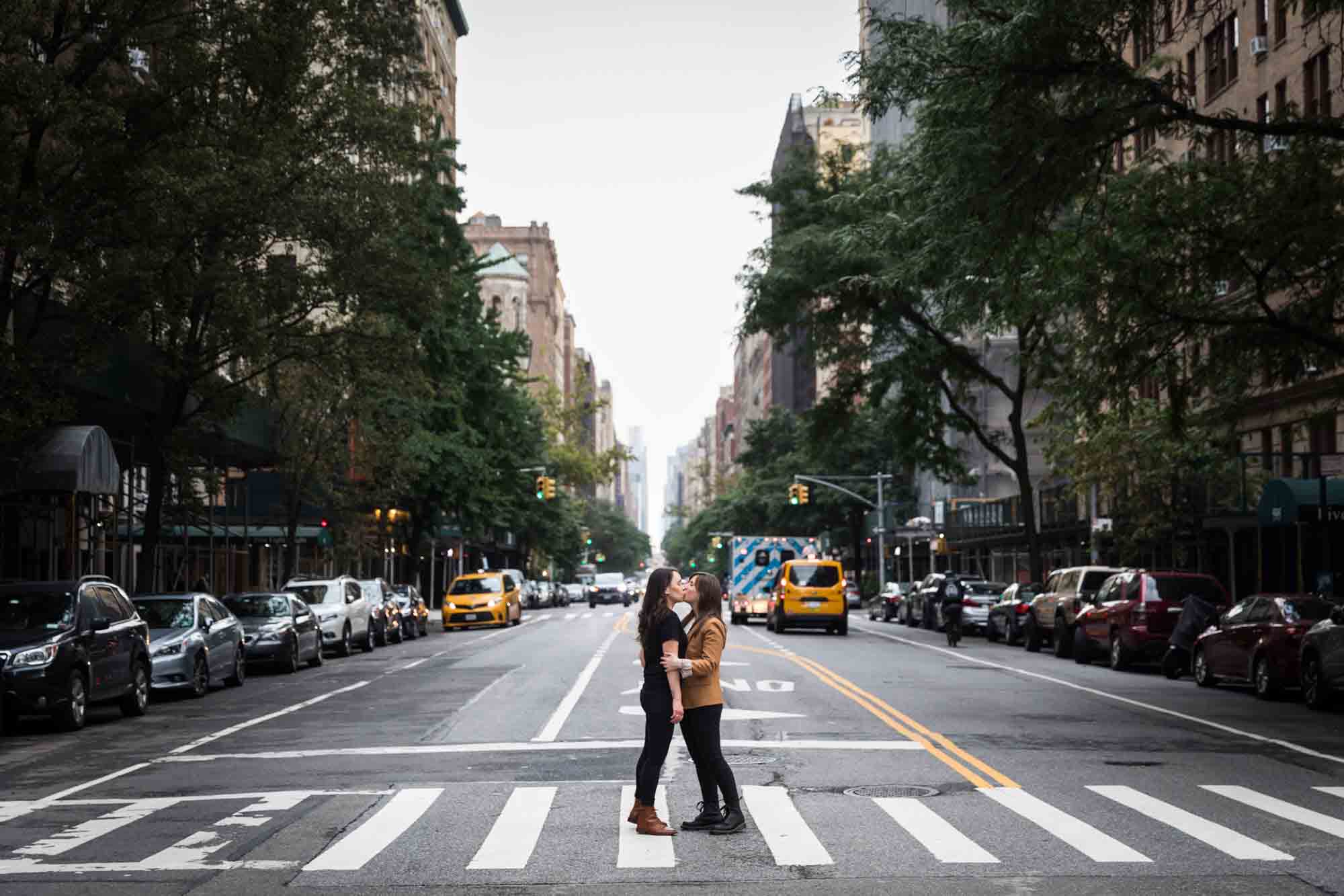Two women kissing in a crosswalk in NYC for an article on how to produce a movie-themed surprise proposal