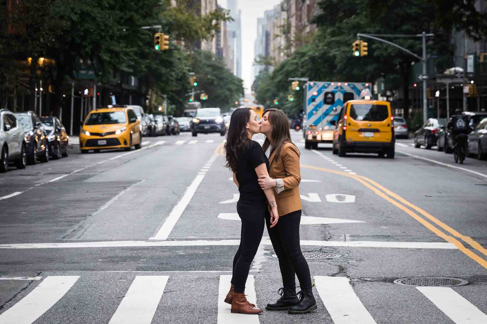 Two women kissing in a crosswalk in NYC for an article on how to produce a movie-themed surprise proposal