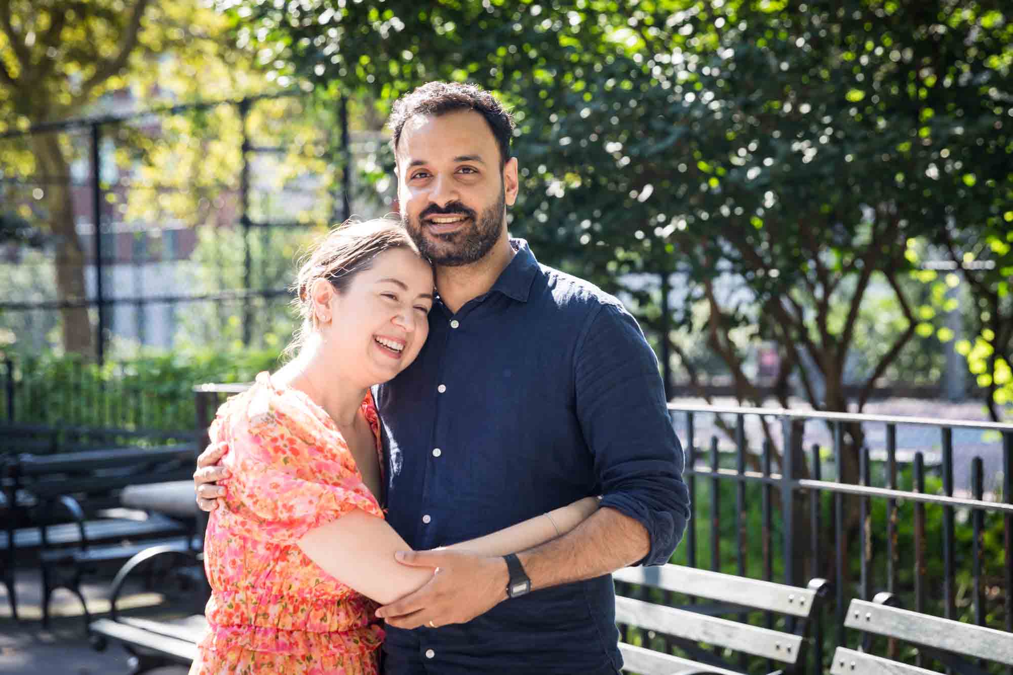 Woman in floral dress huygging man in blue shirt in McLaughlin Park