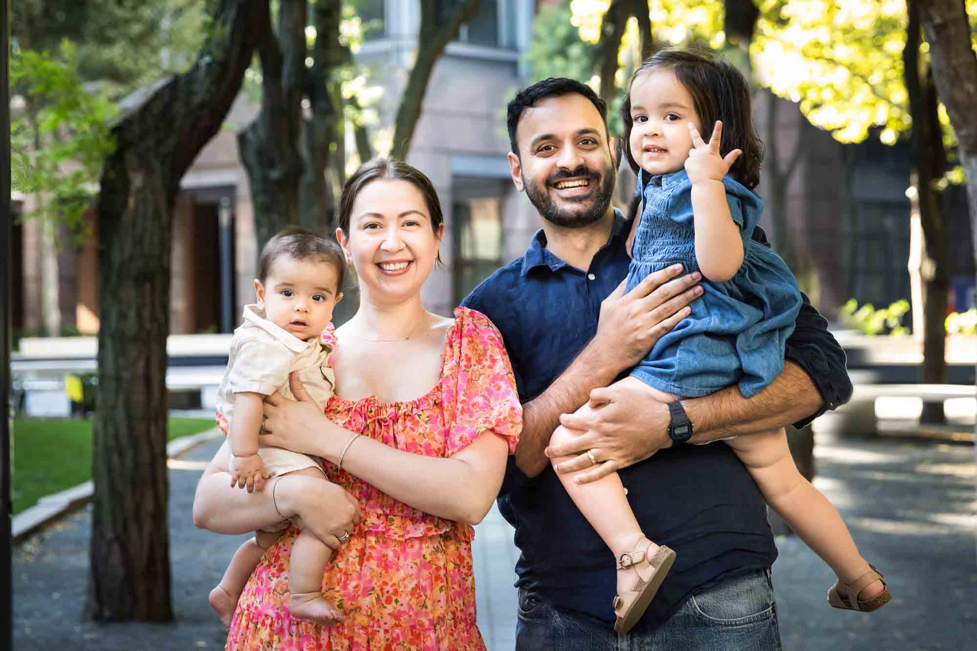 Parents with baby and little girl standing on pathway during a Brooklyn Commons family portrait session